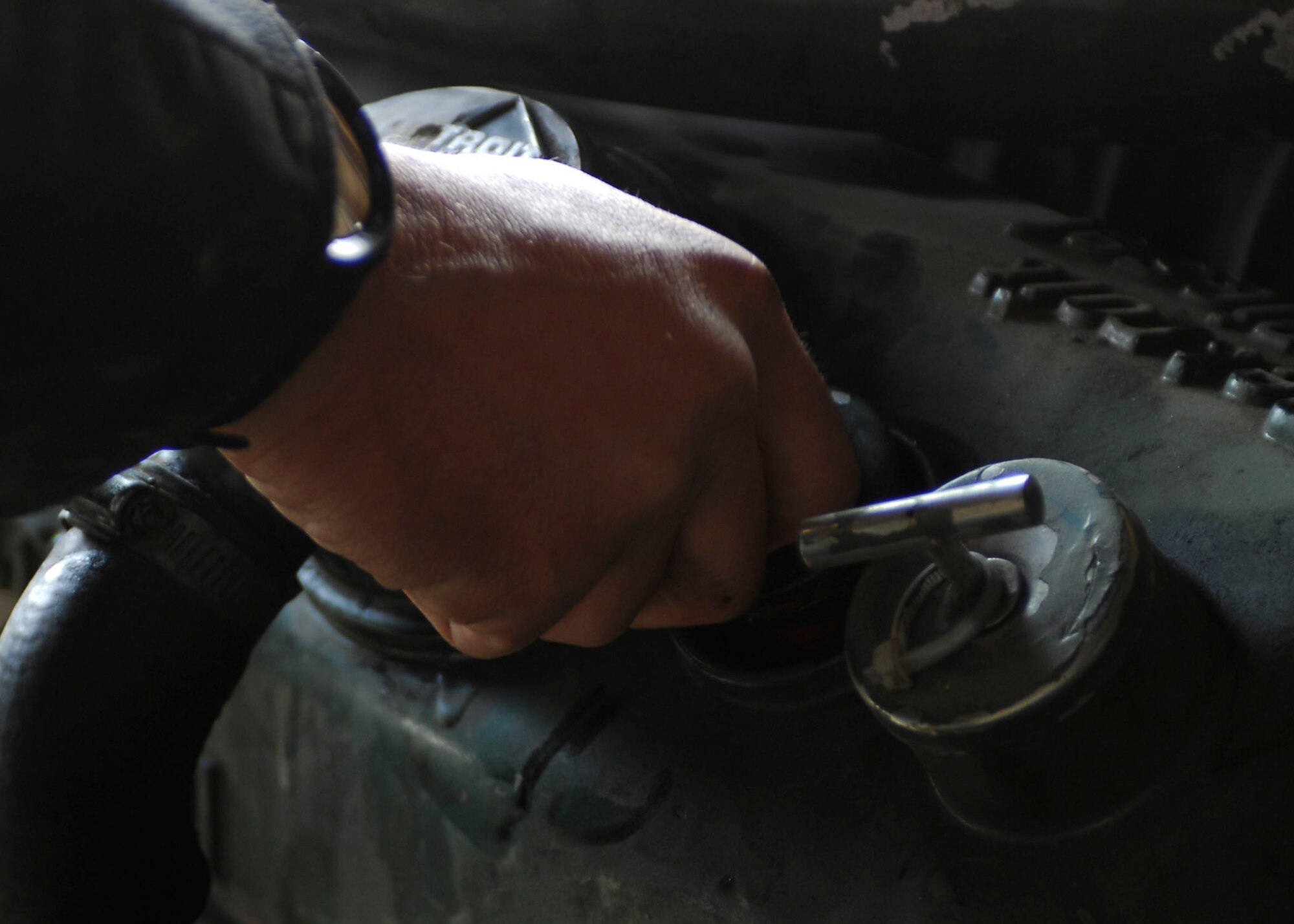 BAGRAM AIRFIELD, Afghanistan -- Staff Sgt. Wayne Collins, a vehicle maintenance craftsman from the 455th Expeditionary Logistics Readiness Squadron, attaches an engine cover during an inspection Oct. 28, 2009.  The 455th ELRS is responsible for fuels, vehicle maintenance, logistics planning, passenger terminal operations and air terminal operations.  Sergeant Collins is deployed from Eglin Air Force Base, Fla., and hails from Calhoun, Ga.  (U.S. Air Force photo/Senior Airman Felicia Juenke)