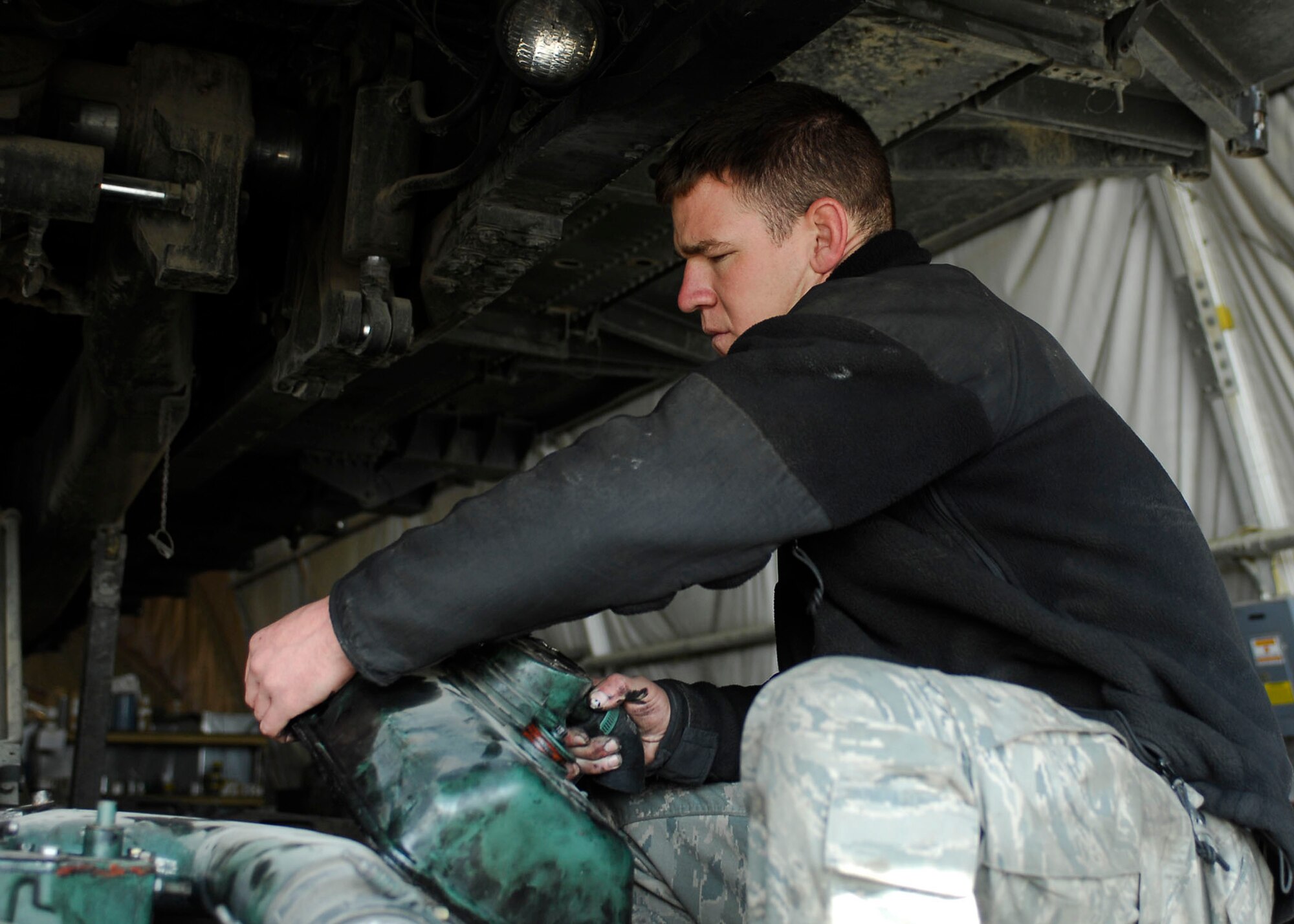 BAGRAM AIRFIELD, Afghanistan -- Staff Sgt. Wayne Collins, a vehicle maintenance craftsman from the 455th Expeditionary Logistics Readiness Squadron, removes an engine cover during an inspection Oct. 28, 2009.  The 455th ELRS is responsible for fuels, vehicle maintenance, logistics planning, passenger terminal operations and air terminal operations.  Sergeant Collins is deployed from Eglin Air Force Base, Fla., and hails from Calhoun, Ga.  (U.S. Air Force photo/Senior Airman Felicia Juenke)
