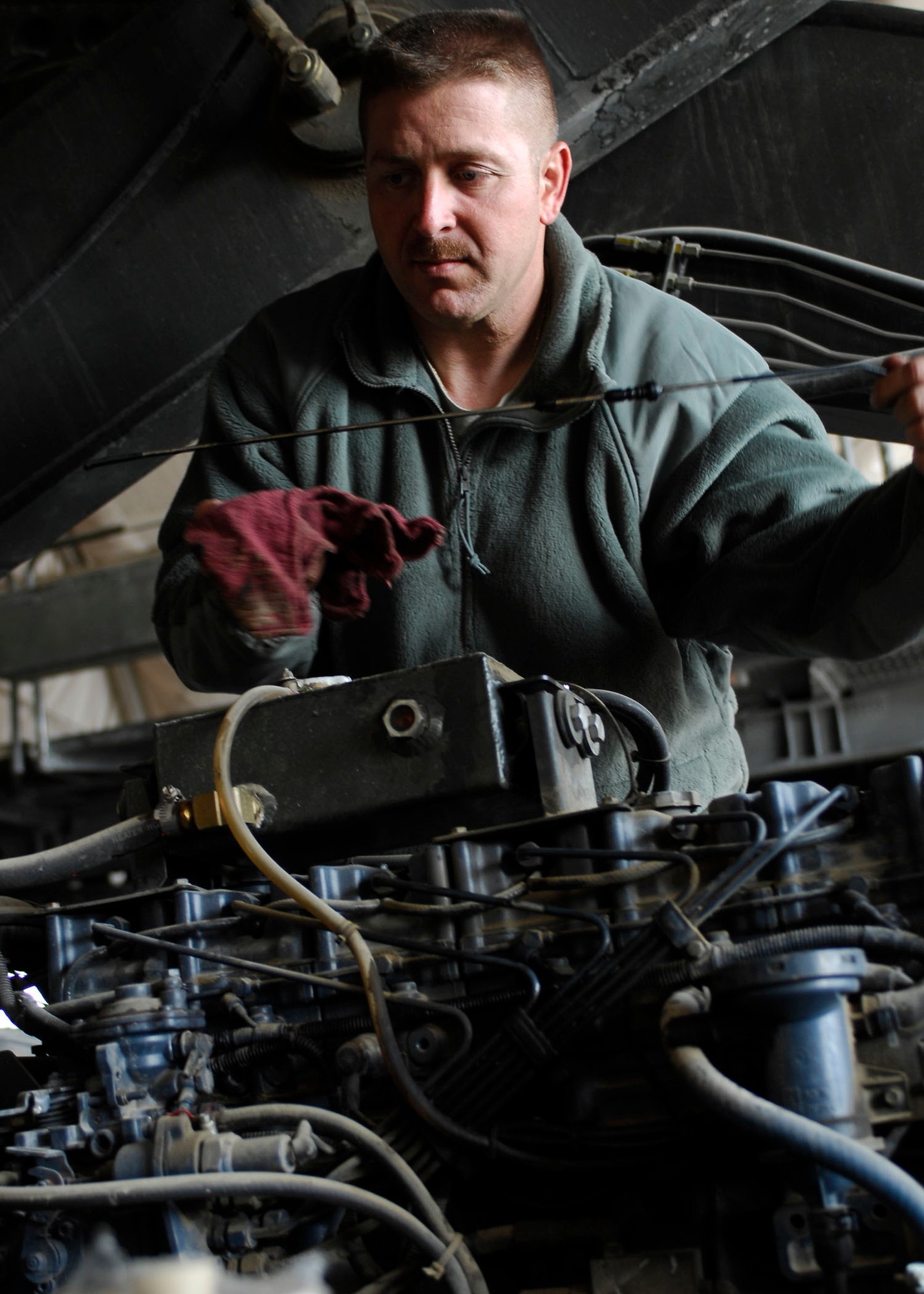BAGRAM AIRFIELD, Afghanistan -- Tech. Sgt. Marco Hoffman, noncommissioned officer-in-charge of the Material Handling Equipment Shop from the 455th Expeditionary Logistics Readiness Squadron, checks the level of all the liquids in the engine during an inspection Oct. 28, 2009.  The 455th ELRS is responsible for fuels, vehicle maintenance, logistics planning, passenger terminal operations and air terminal operations.  Sergeant Hoffman is deployed from McChord Air Force Base, Wash., and hails from Cincinnati, Ohio.  (U.S. Air Force photo/Senior Airman Felicia Juenke)
