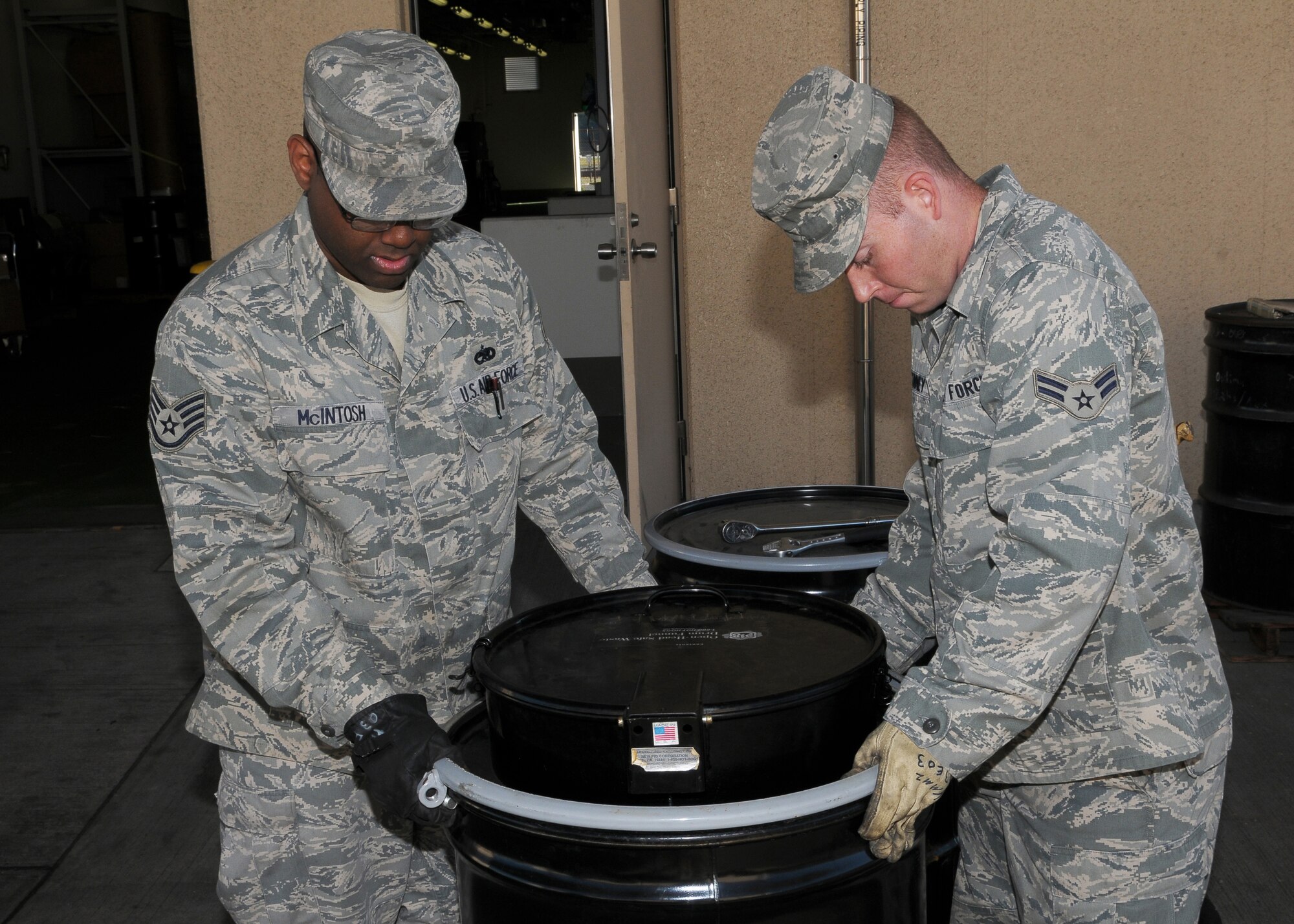 YOKOTA AIR BASE, Japan -- Staff Sgt. Dominic McIntosh, 374th Maintenance Squadron aerospace propulsion technician, (left) and Airman 1st Class Justin McKinney, 374th MXS aerospace propulsion apprentice, remove the lid on a hazardous waste barrel Oct. 27. in preparation for an upcoming assessment. A team of inspectors will scour the base Nov. 2-6 as part of the 2009 Internal Environmental Safety Occupational and Health Compliance Assessment Management Program audit. (U.S. Air Force photo/Airman 1st Class Sean Martin)