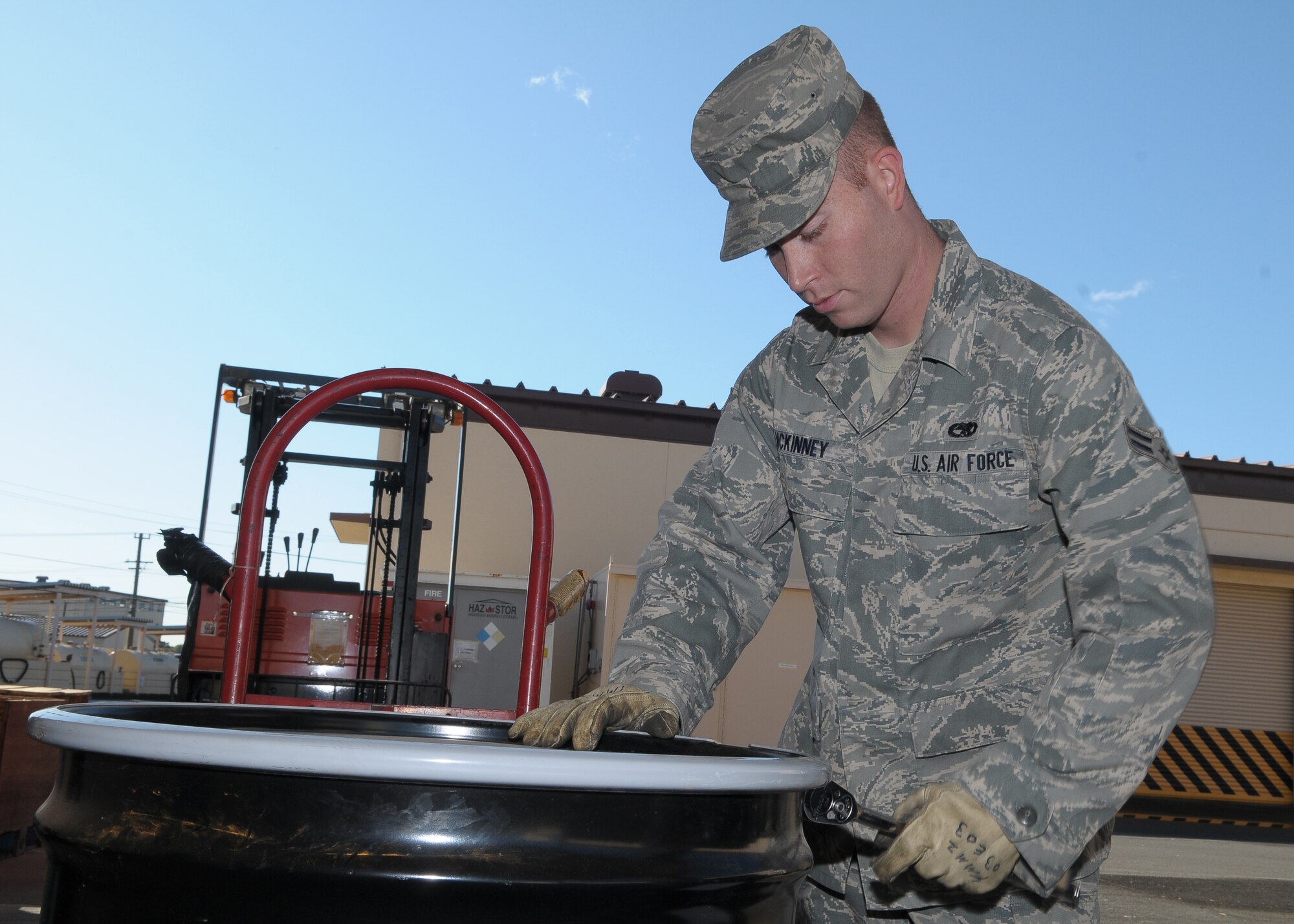 YOKOTA AIR BASE, Japan -- Airman 1st Class Justin McKinney, 374th Maintenance Squadron aerospace propulsion apprentice, tightens the lid on a barrel of hazardous waste Oct. 27. in preparation for an upcoming assessment. A team of inspectors will scour the base Nov. 2-6 as part of the 2009 Internal Environmental Safety Occupational and Health Compliance Assessment Management Program audit. (U.S. Air Force photo/Airman 1st Class Sean Martin)