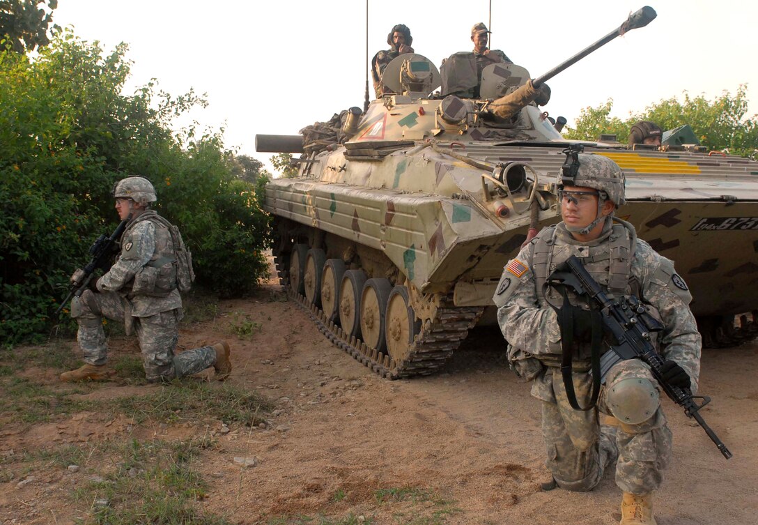 U.S. Army Staff Sgt. Kris Jorgensen, left, and Spc. Jason Echevarria maneuver with Indian soldiers and their Boyevaya Machina Pekhoty tank, a soviet amphibious tracked infantry fighting vehicle, during Yudh Abyas on Camp Bundela, India, Oct. 25, 2009. Jorgensen and Echevarria are assigned to the 25th Infantry Division's 2nd Squadron, 14th Cavalry Regiment, 2nd Stryker Brigade Combat Team.