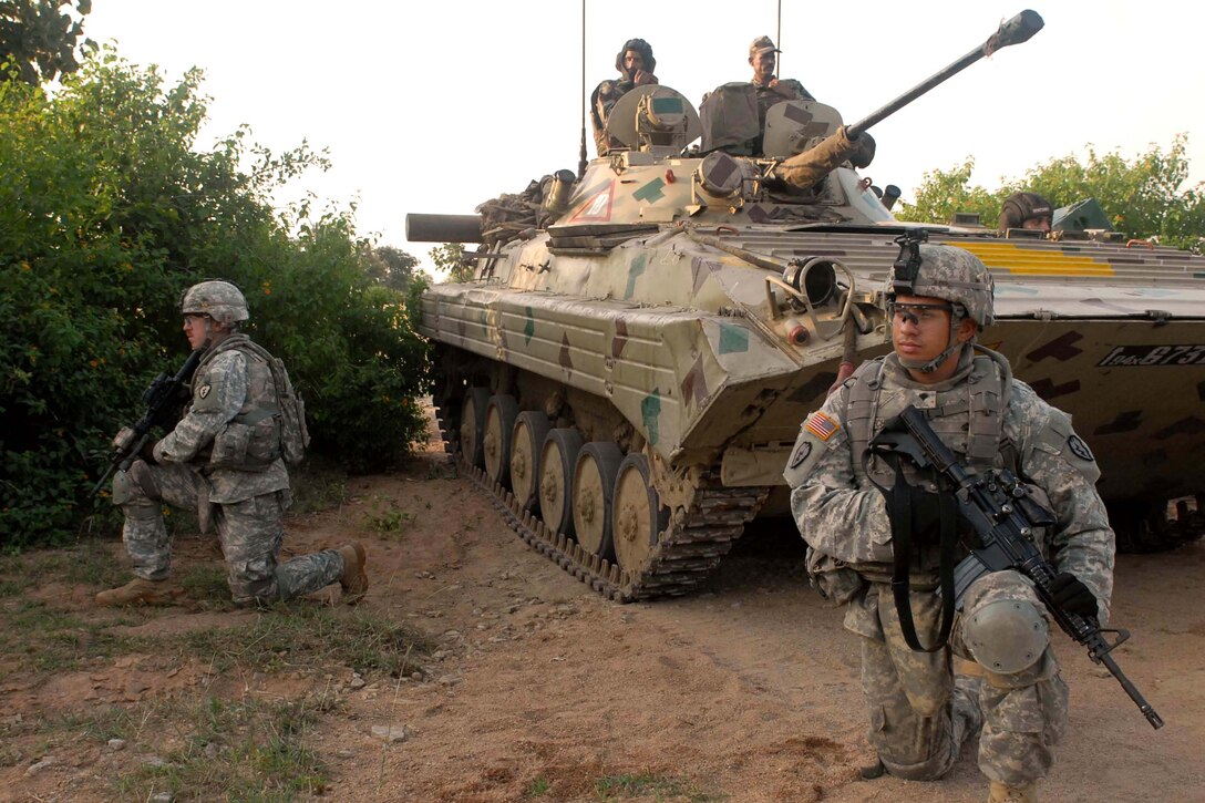 From left, Staff Sgt. Kris Jorgensen and Spc. Jason Echevarria maneuver with Indian soldiers and their Boyevaya Machina Pekhoty, or BMP tank, a soviet amphibious tracked infantry fighting vehicle, during Exercise Yudh Abyas 09, a bilateral exercise involving the Armies of India and the United States. Both are assigned to the 25th Infantry Division's Troop C, 2nd Squadron, 14th Cavalry Regiment Strykehorse, 2nd Stryker Brigade Combat Team.

