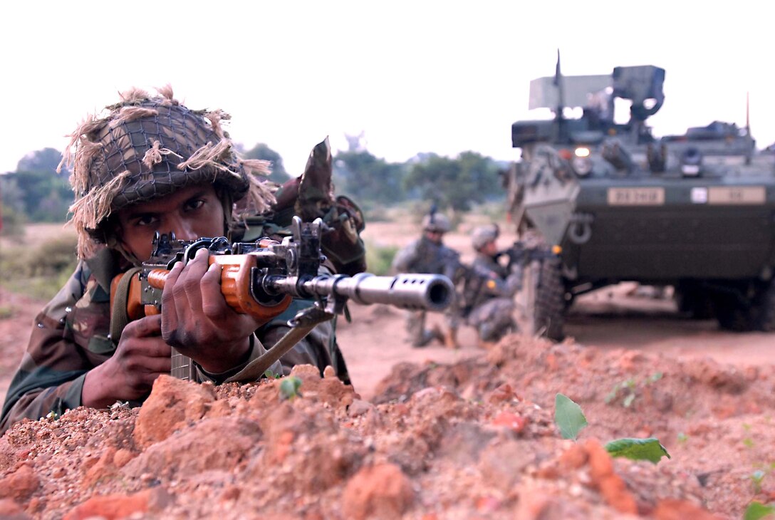 An Indian army soldier, with U.S. soldiers prepares to advance towards a village during a dismounted patrol conducted by both armies during Exercise Yudh Abyas 09, a bilateral exercise involving the Armies of India and the United States. 