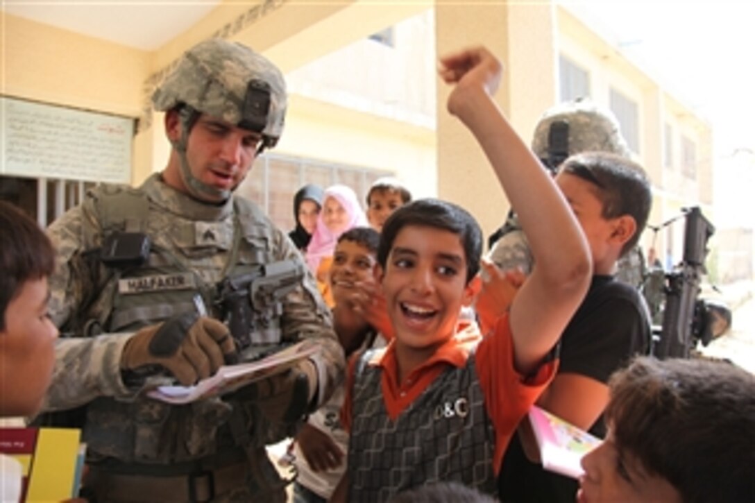U.S. Army Sgt. Matthew Halfaker with the 17th Fires Brigade draws a picture for the children at Tabuk School as Iraqi soldiers and U.S. soldiers conduct a joint patrol of the school and the local district of Hayyaniyah, Iraq, on Oct. 7, 2009.  