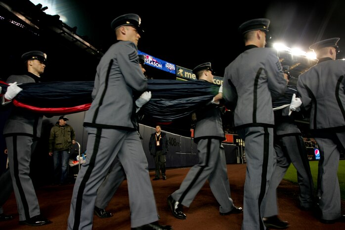 Marines, sailors, airmen, soldiers and West Point cadets bring an outfield-sized American Flag onto Yankee Stadium before the first game of the 2009 World Series, Oct. 28, New York. (Official Marine Corps photo by Sgt. Randall A. Clinton)
