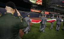 Army Col. Mark J. McKearn, brigade tactical officer, Brigade Tactical Department, US Military Academy West Point, N.Y., salutes the outfield-sized American Flag carried by Marines, sailors, airmen, soldiers and West Point cadets prior to the first game of the 2009 World Series in Yankee Stadium, Oct. 28, New York. The ceremony honored military veterans from all service branches.(Official Marine Corps photo by Sgt. Randall A. Clinton)