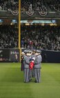 Marines, sailors, airmen, soldiers and West Point cadets wait to unfurl an outfield-sized American Flag across Yankee Stadium prior to the first game of the World Series, Oct 28, New York. The ceremony honored military veterans from all service branches.(Official Marine Corps photo by Sgt. Randall A. Clinton)