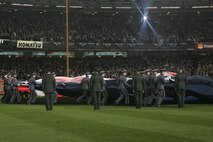 Marines, sailors, airmen, soldiers and West Point cadets unfurl an outfield-sized American Flag across Yankee Stadium prior to the first game of the World Series, Oct 28, New York. The ceremony honored military veterans.(Official Marine Corps photo by Sgt. Randall A. Clinton)