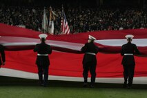 Marines, sailors, airmen, soldiers and West Point cadets unfurl an outfield-sized American Flag across Yankee Stadium prior to the first game of the World Series, Oct 28, New York. The ceremony honored military veterans.(Official Marine Corps photo by Sgt. Randall A. Clinton)