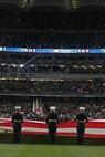 Marines, sailors, airmen, soldiers and West Point cadets unfurl an outfield-sized American Flag across Yankee Stadium prior to the first game of the World Series, Oct 28, New York. The ceremony honored military veterans.(Official Marine Corps photo by Sgt. Randall A. Clinton)