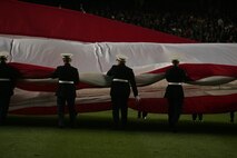 Marines, sailors, airmen, soldiers and West Point cadets unfurl an outfield-sized American Flag across Yankee Stadium prior to the first game of the World Series, Oct 28, New York. The ceremony honored military veterans.(Official Marine Corps photo by Sgt. Randall A. Clinton)