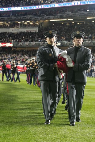 Marines, sailors, airmen, soldiers and West Point cadets march off the field after a pregame ceremony at Yankee Stadium, N.Y., Oct. 28. Service members unfurled a flag across the outfield, and wounded warriors joined a United States Military Academy at West Point color guard prior to the first game of the World Series. The ceremony honored military veterans.(Official Marine Corps photo by Sgt. Randall A. Clinton)