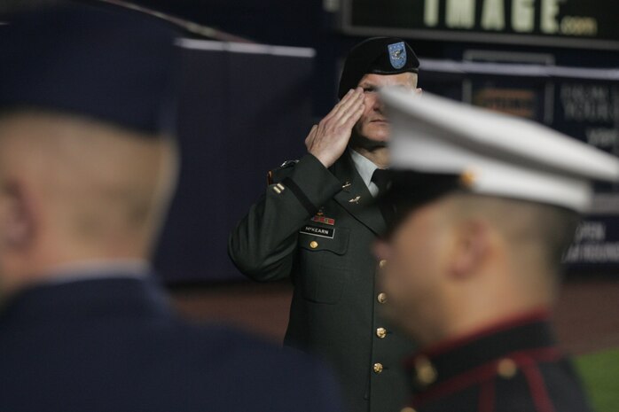 Army Col. Mark J. McKearn, brigade tactical officer, Brigade Tactical Department, US Military Academy West Point, N.Y., salutes the outfield-sized American Flag carried by Marines, sailors, airmen, soldiers and West Point cadets prior to the first game of the 2009 World Series in Yankee Stadium, Oct. 28, New York. The ceremony honored military veterans. (Official Marine Corps photo by Sgt. Randall A. Clinton)