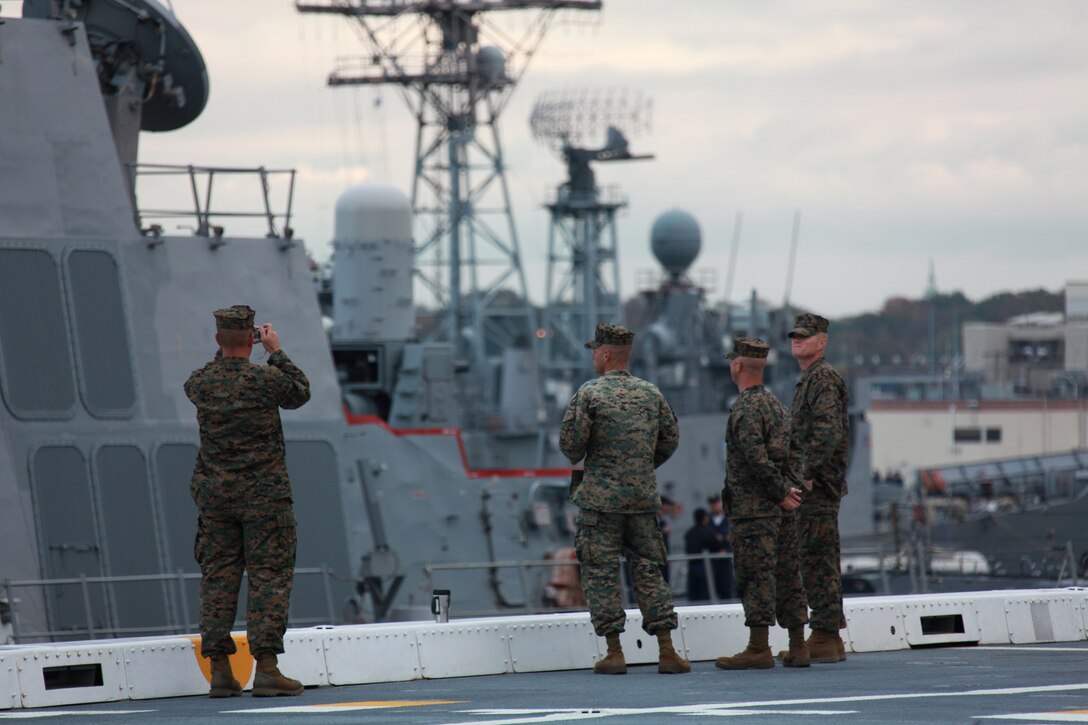 Marines from Special Purpose Marine Air Ground Task Force 26 watch as sailors prepare USS New York to leave the docks at Naval Station Norfolk, Va, Oct. 29, 2009. North Carolina Marines from several units joined to form SPMAGTF-26 to support the ship’s commissioning in New York City, Nov. 7.::r::::n::::r::::n::