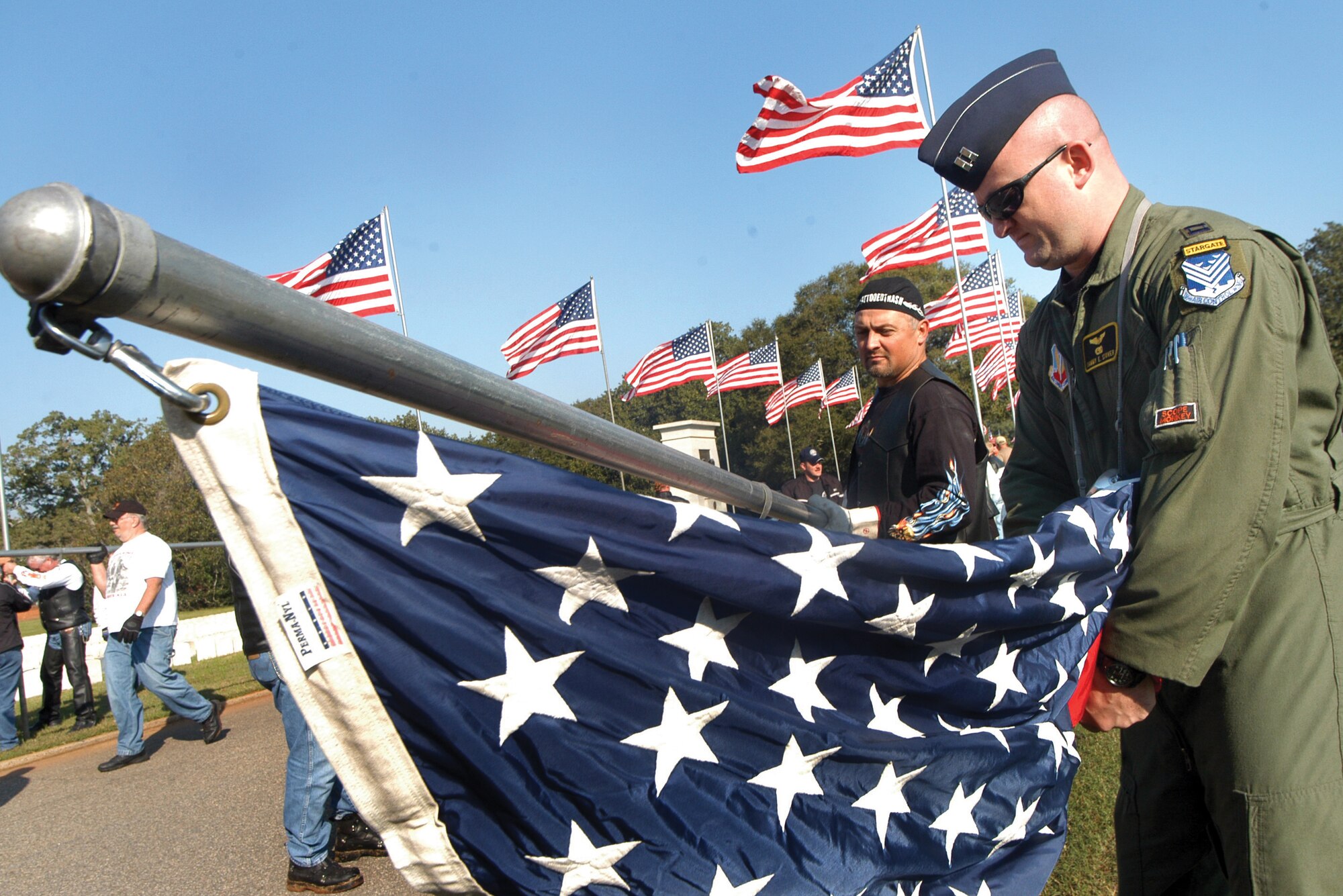 Capt. Sammy Stover, 330th Combat Training Squadron, attaches a flag to a pole before it is raised at Andersonville National Cemetery Nov. 2. U. S. Air Force photo by Sue Sapp   