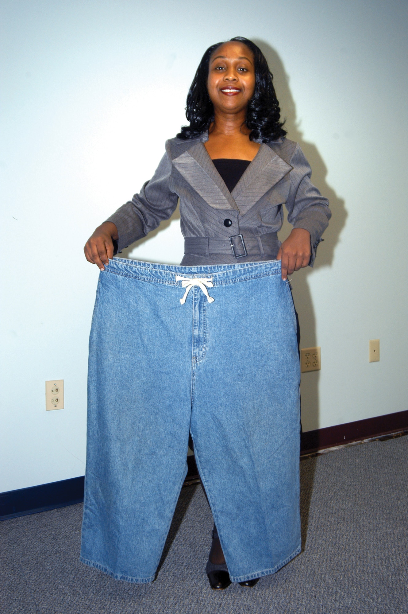 Natasha Dunomes shows off a pair of pants she wore before losing 110 pounds. U. S. Air Force photo by Sue Sapp   