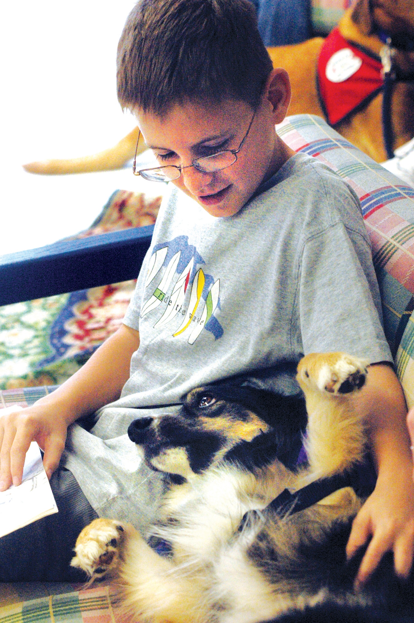 Dylan Fiveash reads to Nora, the therapy dog. U. S. Air Force photo by Sue Sapp