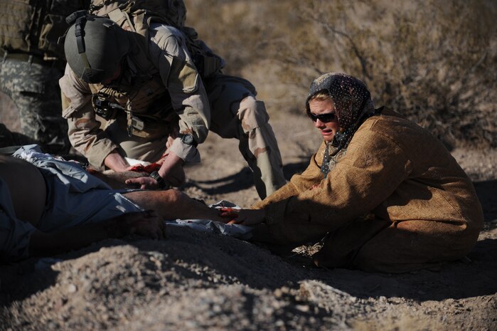 NEVADA TEST and TRAINING RANGE, Nev. -- A U.S. Air Force Joint Terminal Attack Controller Airman treats a simulated civilian victim from a simulated roadside bomb while the victim's wife grieves over her husband during a training exercise at the Urban Operations Center on the Nevada Test and Training Range, Oct. 21, 2009. Special Forces Units from all branches of service and allied nations use the facilities on the NTTR for a multitude of different training. (U.S. Air Force photo by Airman 1st Class Brett Clashman/Released)