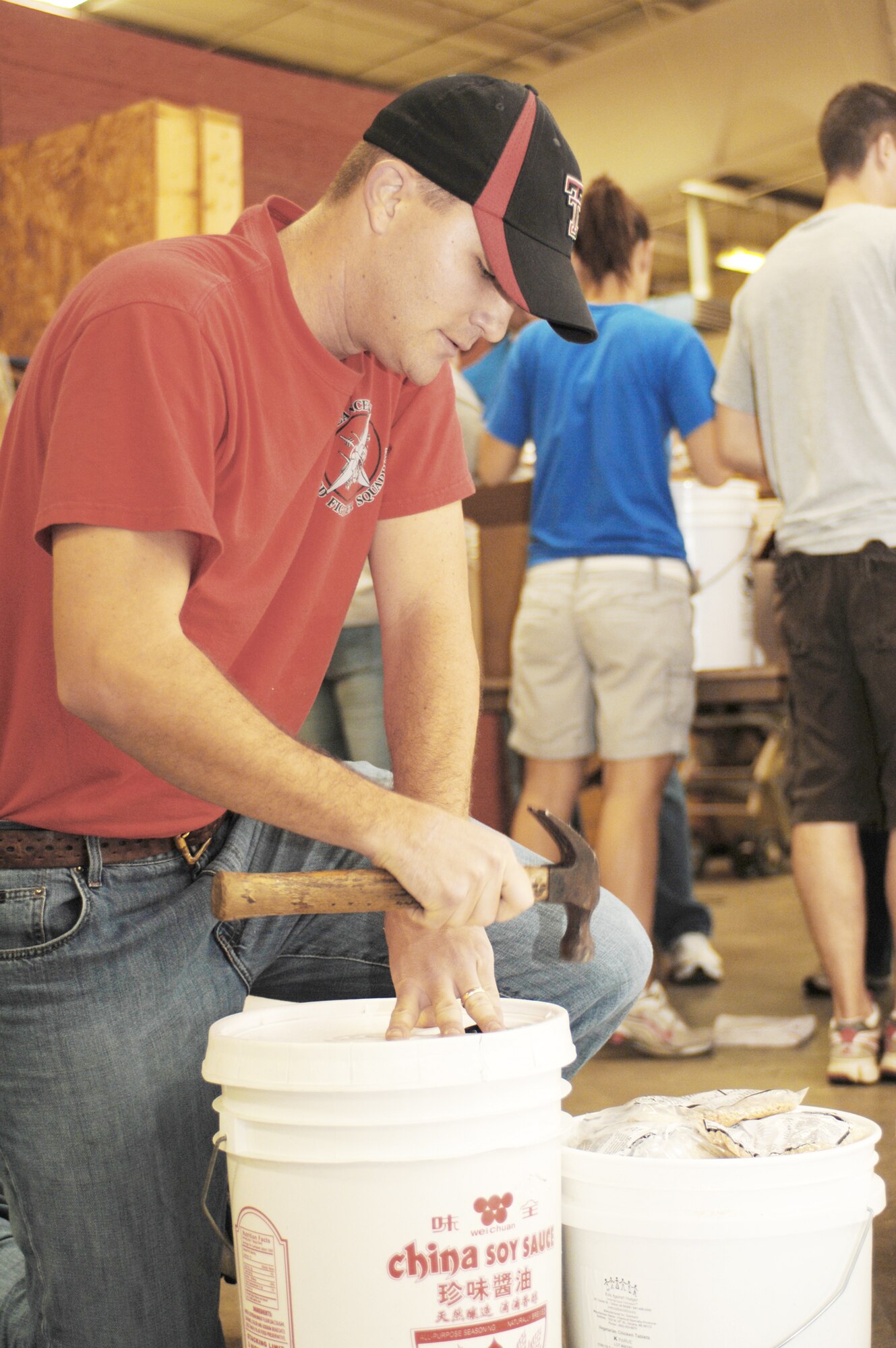 1st Lt. Michael Hefferly hammers down a bucket full of rice- and soy-based meals for shipment to Afghanistan during the Stop Hunger Now event Oct. 24, 2009, at the MERCI Mission Center in Goldsboro, N.C. The items are shipped to Afghanistan courtesy of the Denton Program, which allows private U.S. citizens and organizations to use space available on U.S. military cargo planes to transport humanitarian goods and supplies to countries in need. Lieutenant Hefferly is a 333rd Fighter Squadron weapon system officer from Seymour Johnson Air Force Base, N.C. (U.S. Air Force photo/Staff Sgt. Heather Stanton) 