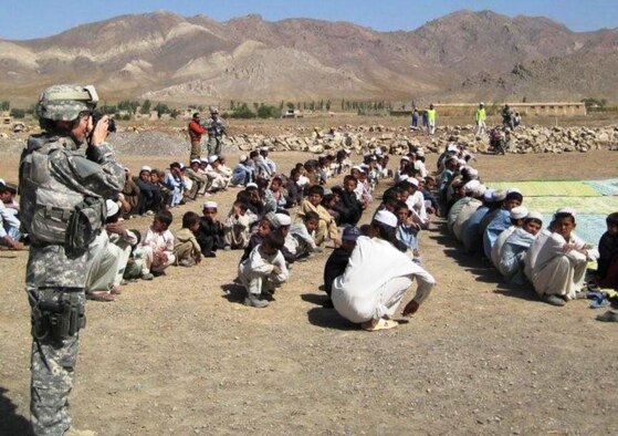 Capt Beverly Mock, 43rd Airlift Wing public affairs officer from Pope Air Force Base, N.C., takes photos during a school ground breaking ceremony while deployed as an information operations officer with the Gardez Provincial Reconstruction Team in Afghanistan in 2008. (Courtesy Photo)