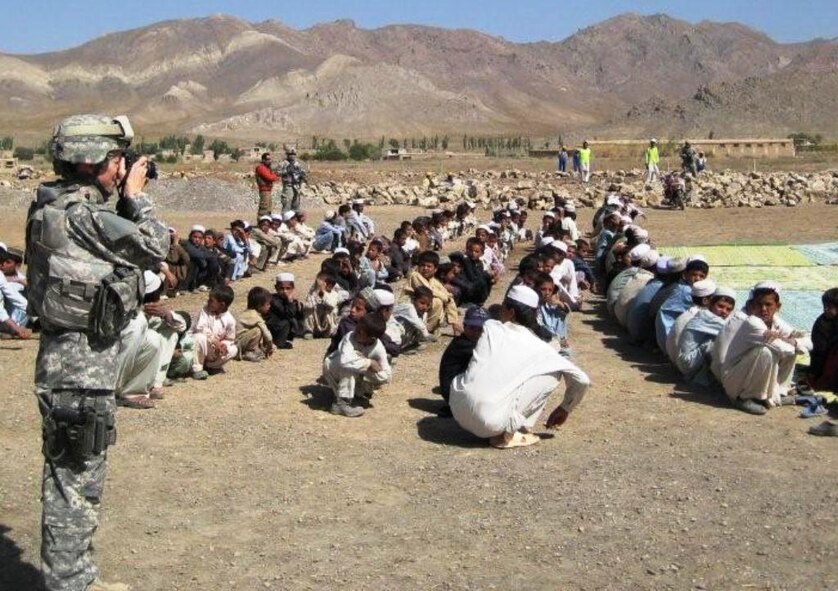 Capt Beverly Mock, 43rd Airlift Wing public affairs officer from Pope Air Force Base, N.C., takes photos during a school ground breaking ceremony while deployed as an information operations officer with the Gardez Provincial Reconstruction Team in Afghanistan in 2008. (Courtesy Photo)