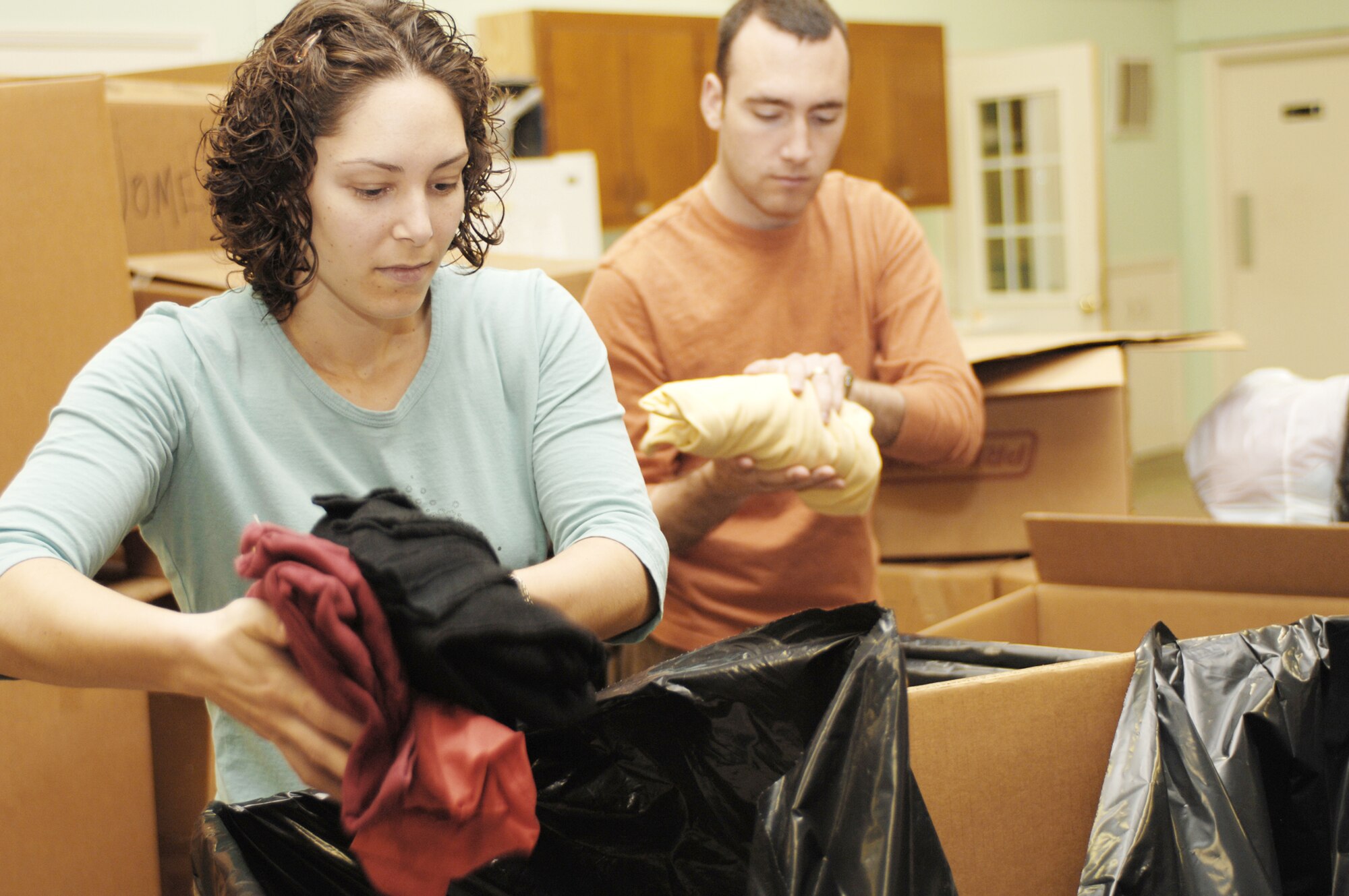 Beth Teegarden and her husband, Capt. Conor Teegarden, package winter clothing into large bags headed to Afghanistan during the Stop Hunger Now event Oct. 24, 2009, at the MERCI Mission Center in Goldsboro, N.C. The event transpired as an idea from the Seymour Johnson Air Force Base, N.C., chaplains and the Rev. Billy Olsen, a Pine Forest United Methodist Church pastor in North Carolina, as a way to bring together members of the base and local community. Captain Teegarden is a 333rd Fighter Squadron weapon system officer. (U.S. Air Force photo/Staff Sgt. Heather Stanton) 