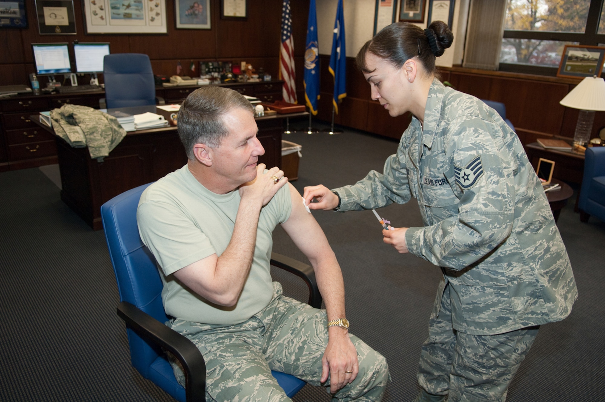 HANSCOM AIR FORCE BASE, Mass. -- Lt. Gen. Ted Bowlds, prepares to receive his influenza vaccine from Staff Sgt. Khalilah Velez, 66th Medical Group, on Oct. 27. Seasonal influenza vaccinations are currently available for active duty personnel, dependents and retirees empanelled to the Hanscom clinic. For questions or additional information call (781) 377-8084. (U.S. Air Force photo by Rick Berry)