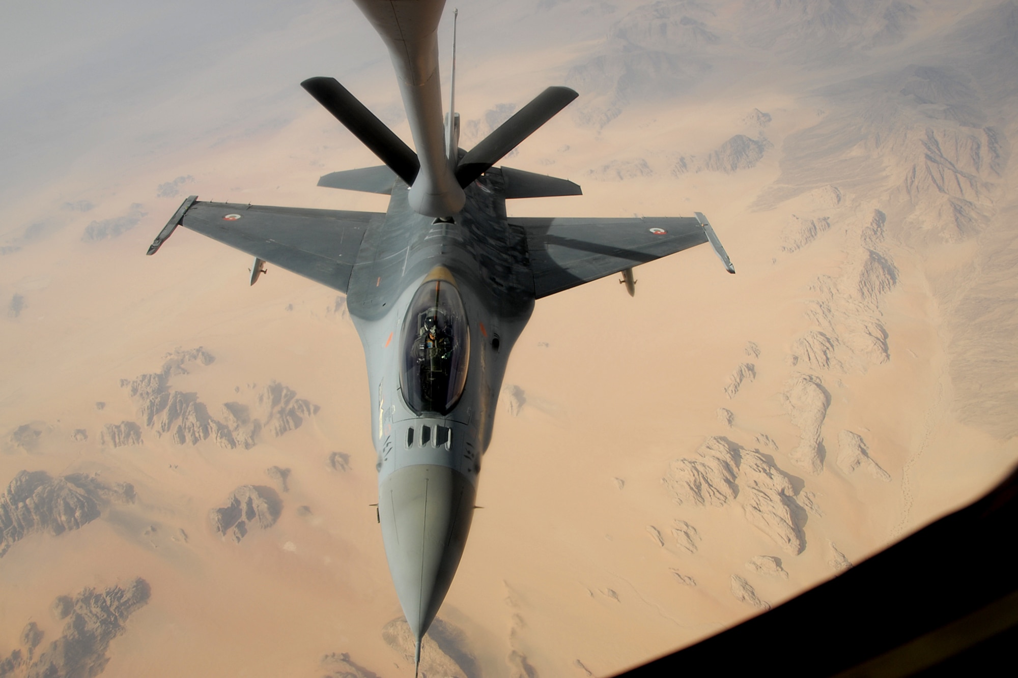 A Royal Jordanian Air Force F-16 Fighting Falcon aircraft fighter pilot flies in to connect to a U.S. Air Force KC-135 Stratotanker aircraft on Oct. 19, 2009, over Jordan, along with other F-16 pilots from the 169th Fighter Wing at McEntire Joint National Guard Base, S.C., and Mwaffaq Salti Air Base in Azraq, Jordan. The air refueling was also being used as a training exercise on the safety and proper procedures for refueling while in flight. U.S. Airmen were in Jordan for the 2009 Eager Tiger 10, Falcon Air Meet, a friendly competition between the air forces of the U.S. and the Middle East, as well as other F-16 aircraft users from around the world. (U.S. Air Force Photo/Tech. Sgt. Caycee Cook)