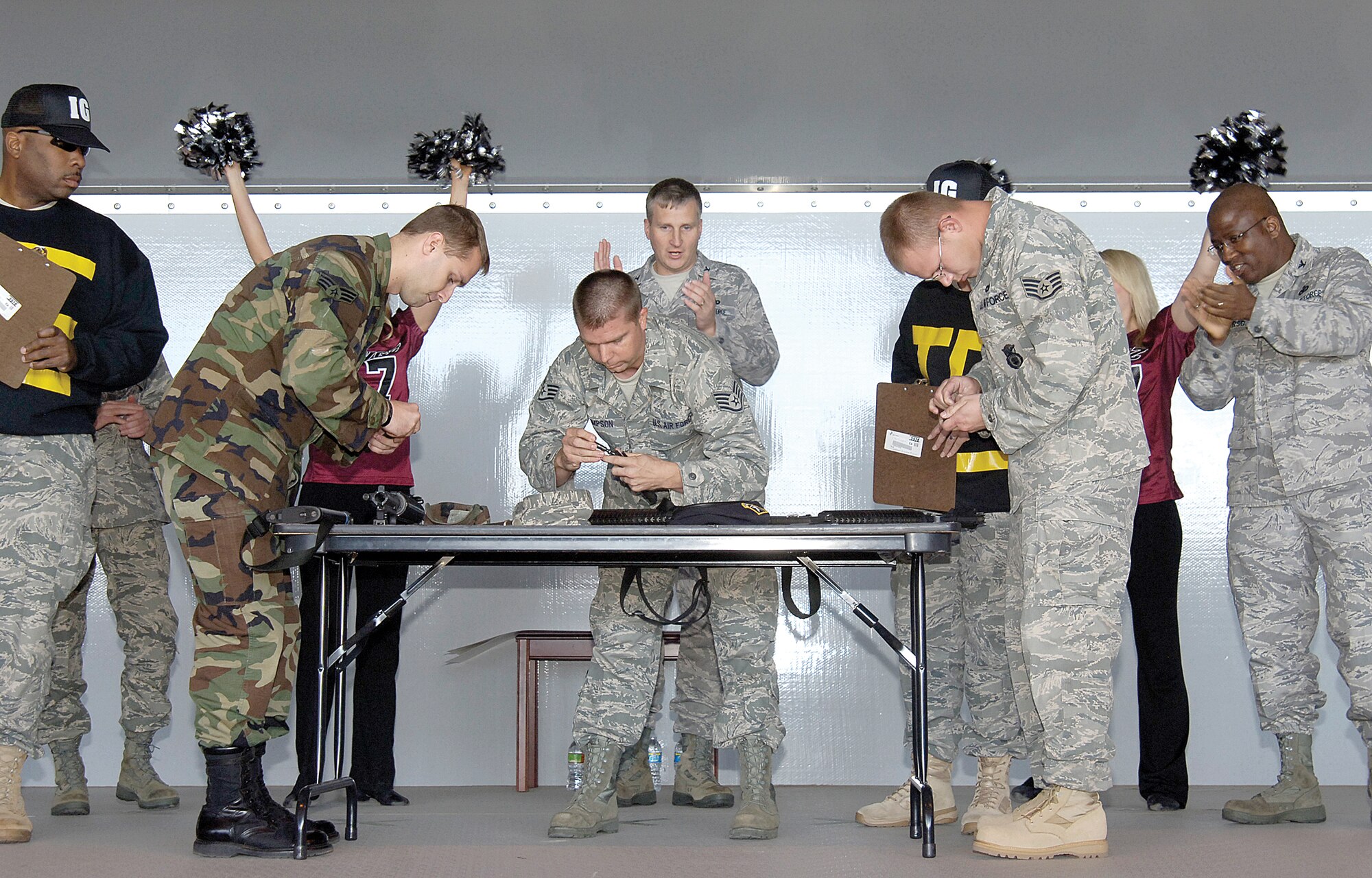 To cheers from the audience, support from wing leadership and Yard Dawgz dancers, and under the eye of “inspectors,” Airmen compete for “Outstanding” bragging rights during the ORI rally Oct. 27. Senior Airman Christopher Moore, 552nd Operations Support Squadron; Staff Sgt. Donald Thompson, 76th Aircraft Maintenance Group; and Staff Sgt. Danny Skelton, 72nd Air Base Wing, tear into their M-16s with Sergeant Skelton earning the win in the end. (Air Force photo by Margo Wright)