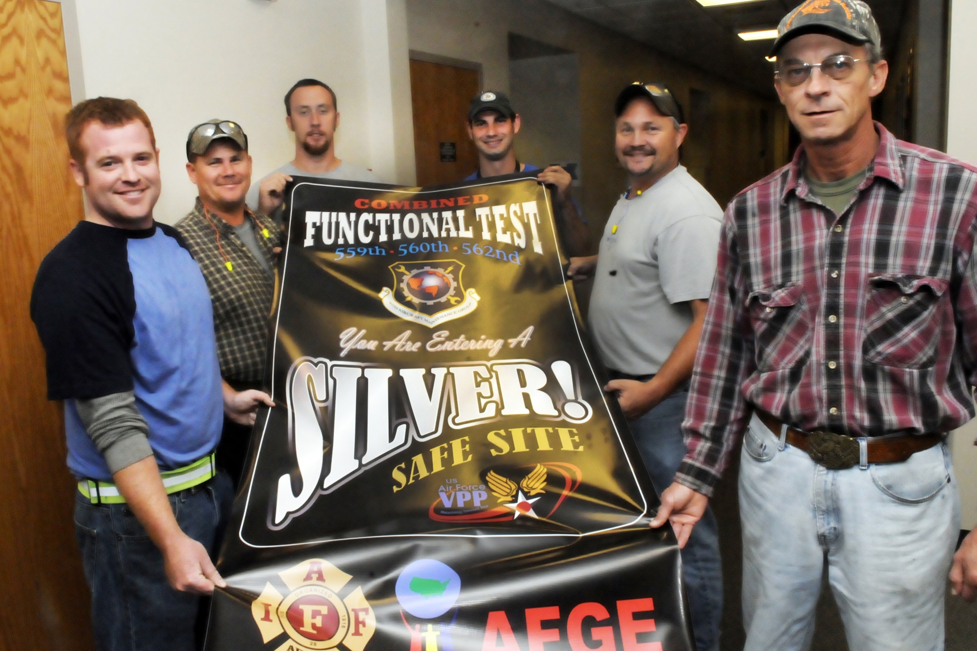 Representatives from the 559th (C-5), 560th (C-130) and the 562nd (C-17) display the VPP Combined Functional Test  banner denoting their status as a silver safe site. Pictured L-R are Keith Capra, Dean Huber, Wesley Kersey, Tony Day, Scott Ball and Craig Coates. U. S. Air Force photo by Sue Sapp