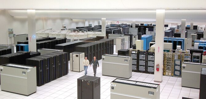 Personnel are dwarfed by servers and computing systems that nearly fill the main computer room of the Defense Information Systems Center Oklahoma City, located north of Bldg. 3001. DISA personnel serve Department of Defense customers worldwide 24-hours-a-day. (Air Force photo by Margo Wright)
