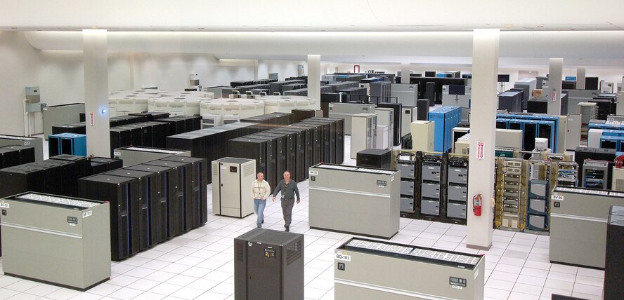 Personnel are dwarfed by servers and computing systems that nearly fill the main computer room of the Defense Information Systems Center Oklahoma City, located north of Bldg. 3001. DISA personnel serve Department of Defense customers worldwide 24-hours-a-day. (Air Force photo by Margo Wright)
