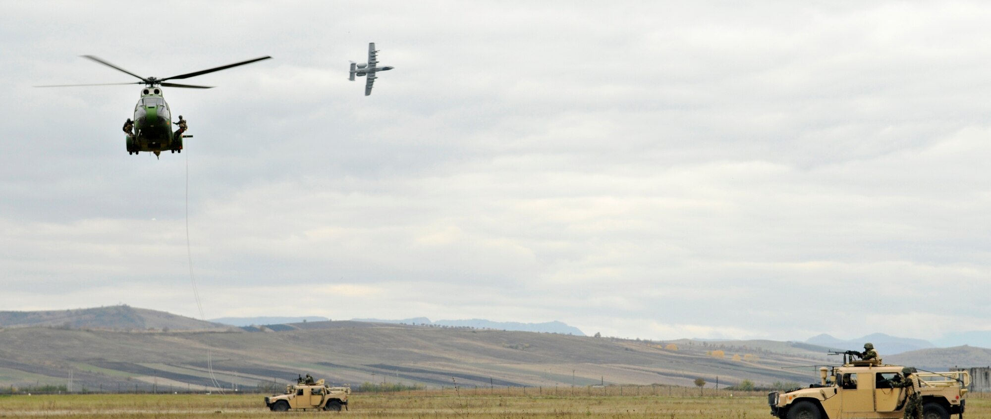 CAMPIA TURZII, Romania – An A-10 Thunderbolt II banks over Humvees and a Romanian Puma helicopter while American and Romanian Airmen jump out during a search and rescue demonstration on the flight line of the 71st Air Base Wing in Romania Oct. 28. Spangdahlem Airmen deployed to Romania in support of Operation Dacian Thunder 2009 and flew about 100 sorties while here; half of which were with the Romanian air force. (U.S. Air Force photo/Senior Airman Benjamin Wilson).