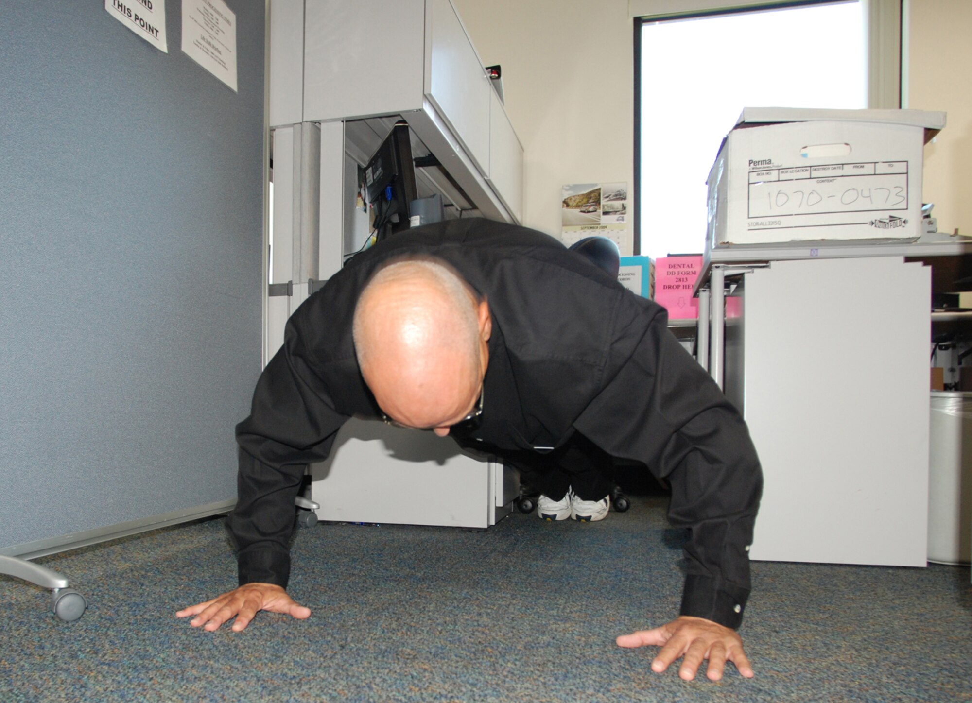 PATRICK AIR FORCE BASE, Fla. - Senior Master Sgt. Bruce Lininger shows his skills while participating in the office-wide Push-up Pals workout. By doing push-ups or sit-ups every hour the team keeps in physical fitness shape all year. (U.S. Air Force Photo/Staff Sgt. Leslie Kraushaar)