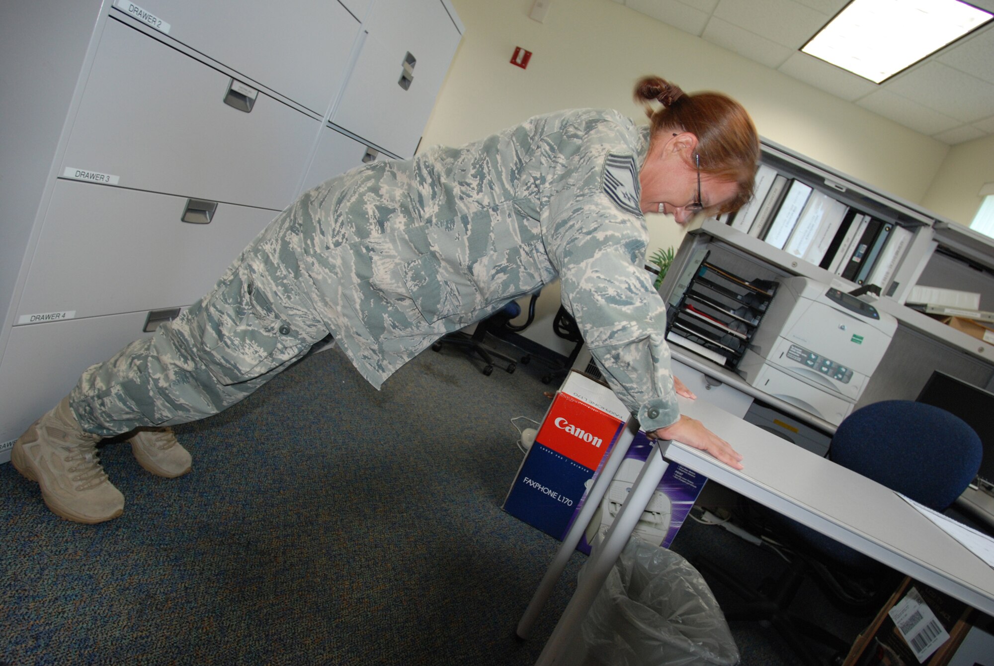 PATRICK AIR FORCE BASE, Fla. - Chief Master Sgt. Lori Martin uses a desk to push it up for the Air Force. Everyone in the office participates to keep current on their physical fitness standards. (U.S. Air Force Photo/Staff Sgt. Leslie Kraushaar)