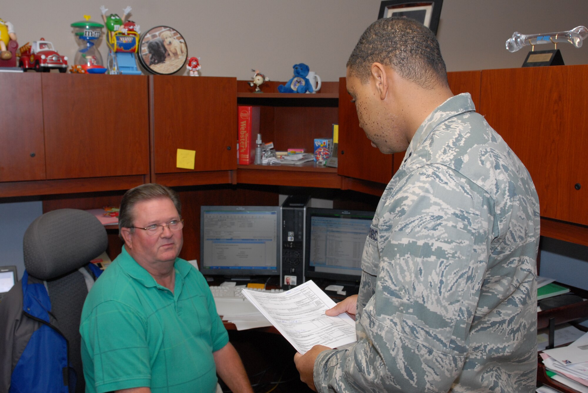 Capt. Reginald Ficklin, 19th Medical Support Squadron Medical Logistics flight commander, discusses purchase orders with Roger Cook, a 19 MDSS purchasing agent. The captain managed a $600,000 war reserve materiel program, keeping it fully mission ready while his flight was 40 percent undermanned due to deployments and separations. Additionally, he managed more than $4 million in clinic renovations, allowing phase IV construction to be completed four months ahead of schedule. (U.S. Air Force photo by Senior Airman Nathan Allen)