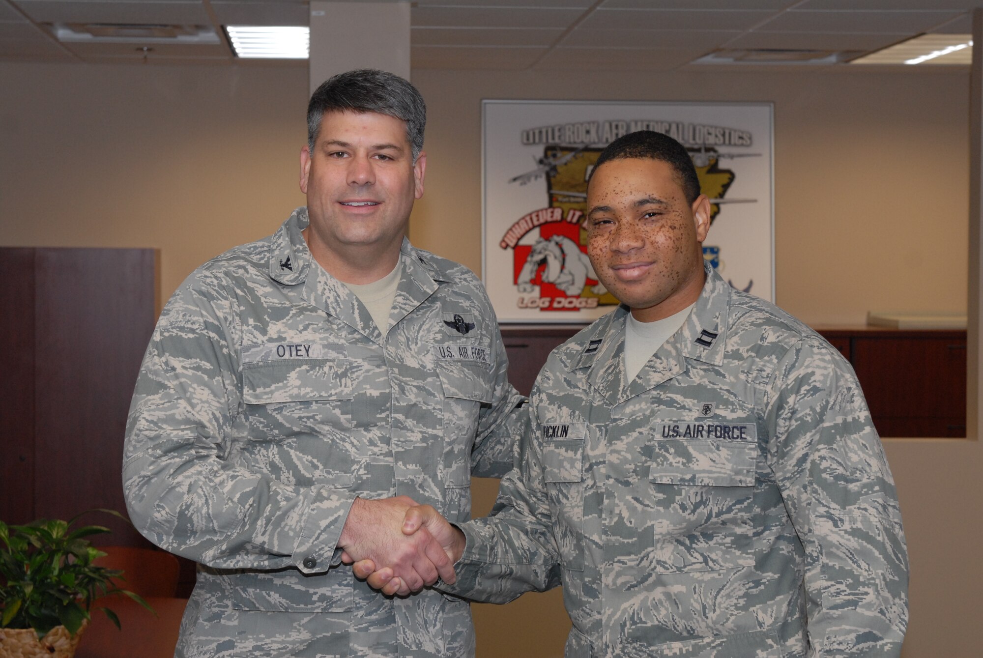Col. Greg Otey, 19th Airlift Wing commander, presents Capt. Reginald Ficklin, 19th Medical Support Squadron Medical Logistics flight commander, with a commander's coin Oct. 20 for his selection as the Combat Airlifter of the Week. Captain Ficklin was the Group 5 point of contact for the Installation Excellence Award team visit, leading the base to a second place finish and a $50,000 reward. He's also a key leader in the base's disease containment plan, procuring a four week supply of flu personal protective equipment, helping ensure the base's defensive posture for the flu season. (U.S. Air Force photo by Senior Airman Nathan Allen)