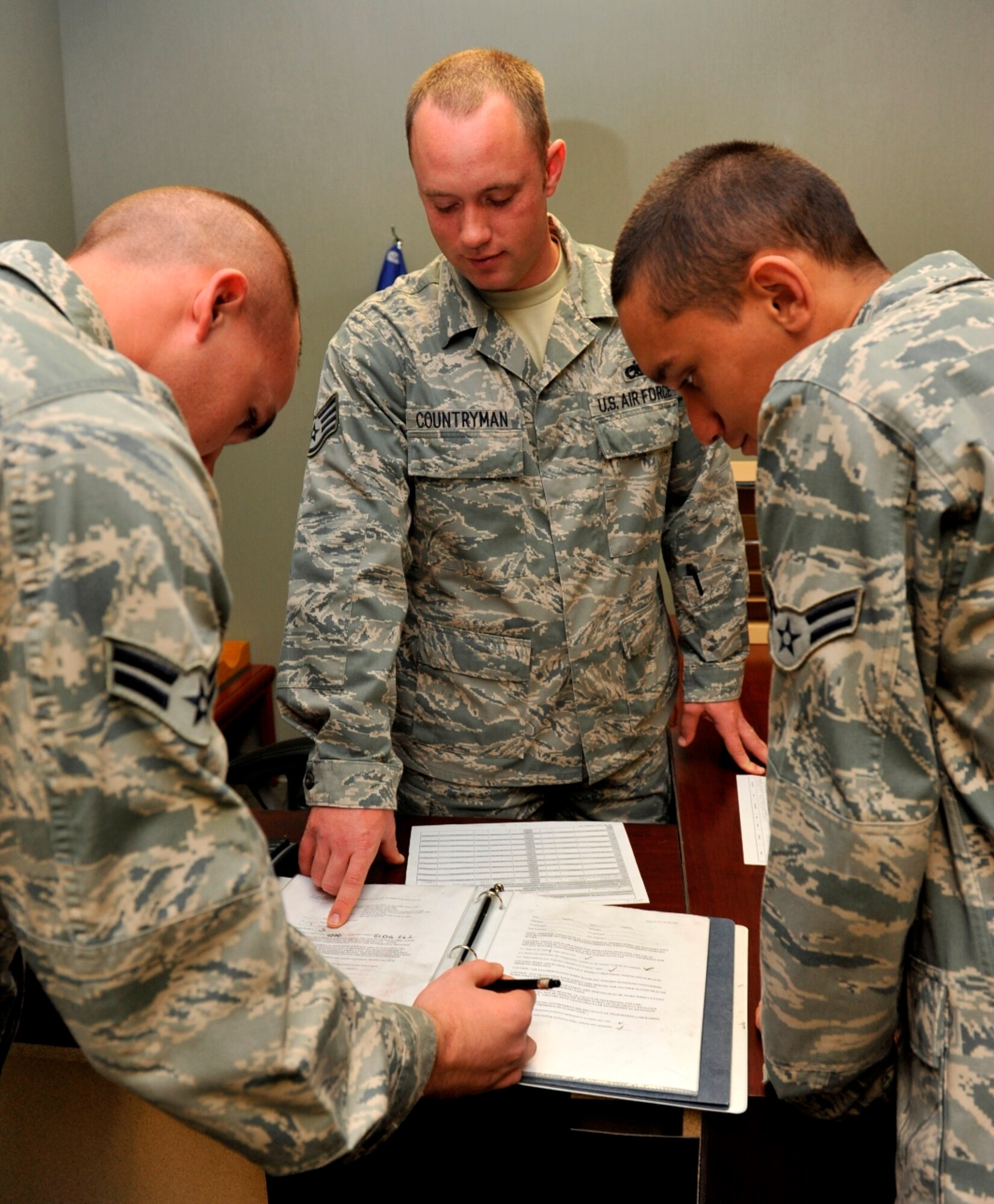 Staff Sgt. Chad Countryman instructs Airman 1st Class Bret Easterling (left), 19th EMS munitions storage crew chief, and Airman 1st Class Scott Smith, 19th EMS storage crew member, in filling out the munitions crew book, in preparation for explosive operations Oct. 27. (U.S. Air Force photo by Airman 1st Class Lausanne Pacheco)