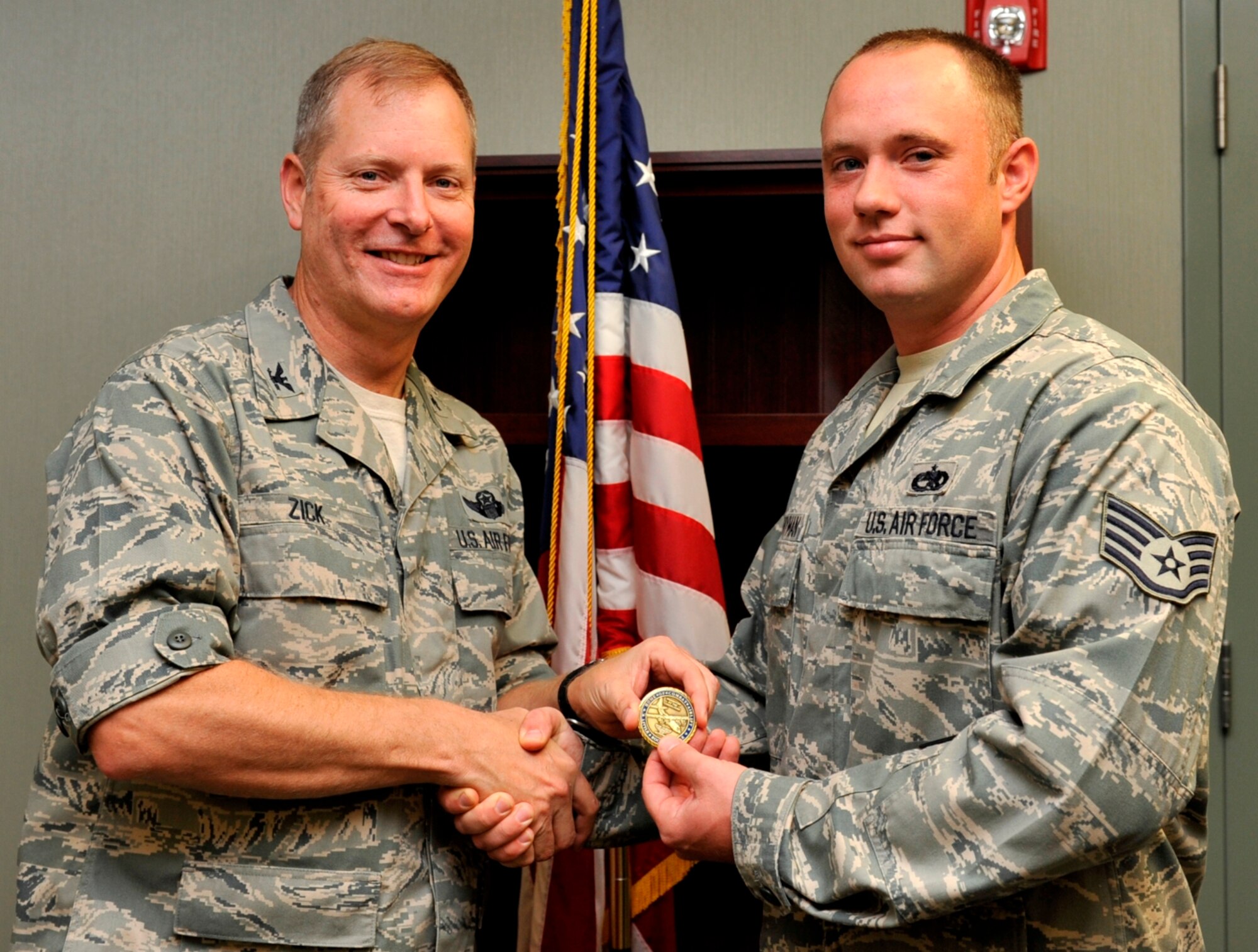 Col. Michael Zick, 19 Airlift Wing vice commander, presents Staff Sgt. Chad Countryman, 19th Equipment Maintenance Squadron assistant non-commissioned officer in charge of munitions accountability, with a commander’s coin Oct. 27 for his selection as the Combat Airlifter of the Week. Sergeant Countryman earned the honor through his performance in providing critical munitions support to 19th Civil Engineer Squadron explosive ordinance disposal flight which enabled the destruction of 130 potential explosive hazards found statewide through civilian assistance agreements with local law enforcement agencies. (U.S. Air Force photo by Airman 1st Class Lausanne Pacheco)