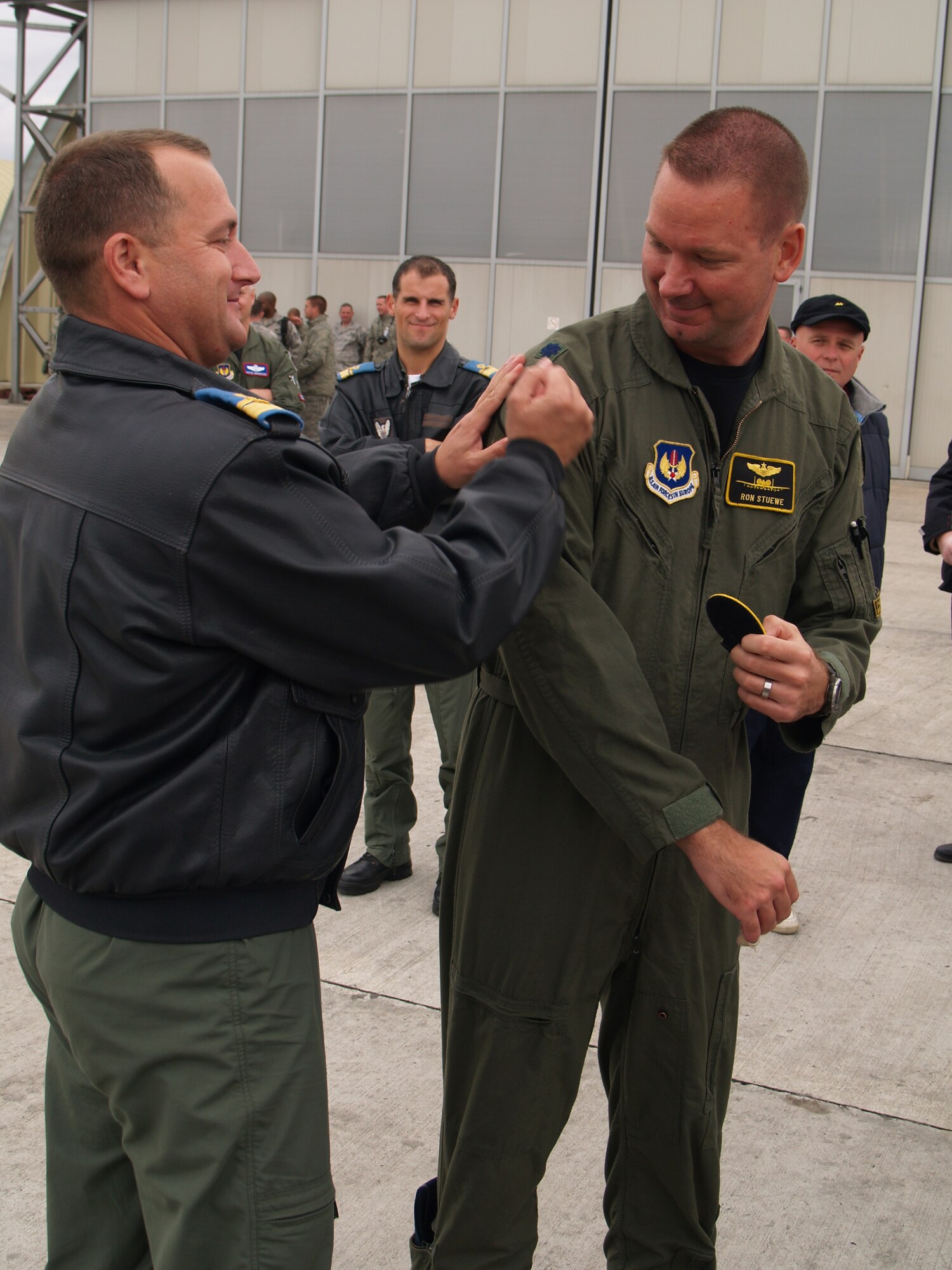 CAMPIA TURZII, Romania – Commander Laurian Anastasof, 71st Air Base Wing commandant, exchanges patches with Lt. Col. Ronald Steuwe, 81st Fighter Squadron commander, after the last day of combined flying exercises in support of Operation Dacian Thunder. Gen. Roger Brady, U.S. Air Forces in Europe commander; Mark Gitenstein, U.S. Ambassador to Romania; and Maj. Gen. Ion-Aurel Stancui, Chief of Staff of the Romanian Air Force; visited the base and viewed an aerial demonstration during the operation. During the combined training exercise the U.S. Air Force flew about 100 sorties; half of which were flown with the Romanian air force. (U.S. Air Force photo/ Captain Greg Hignite)