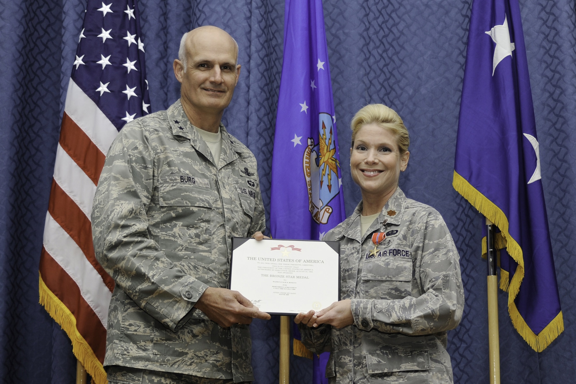 Maj. Gen. Roger Burg, 20th Air Force commander, poses with Maj. Natalie Bonetti, 341st Missile Wing inspector general, after presenting her with the Bronze Star medal Oct. 22 for achievements while deployed. (U.S. Air Force photo/Beau Wade)