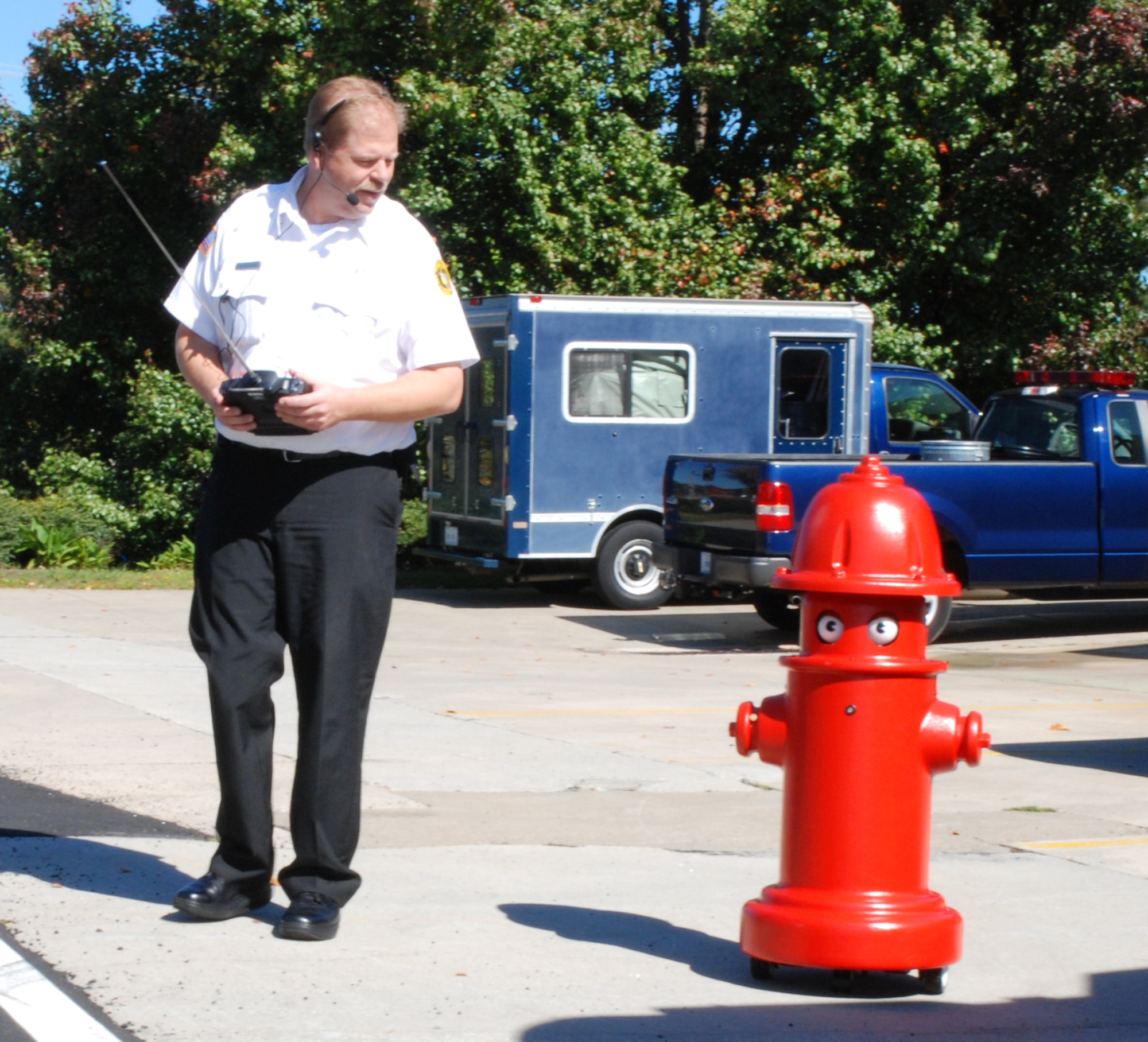 Mark A. Berkenmeier, Dobbins Air Reserve Base Fire Emergency Services fire protection inspector, controls Pluggie by a hand-held remote-control transmitter.   

“Pluggie attracts more attention and interest in our fire prevention messages,” he said.  “Having a robot to deliver our presentations will work well with all audiences, especially our youth.”  (U.S. Air Force photo/Master Sgt. Stan Coleman)
