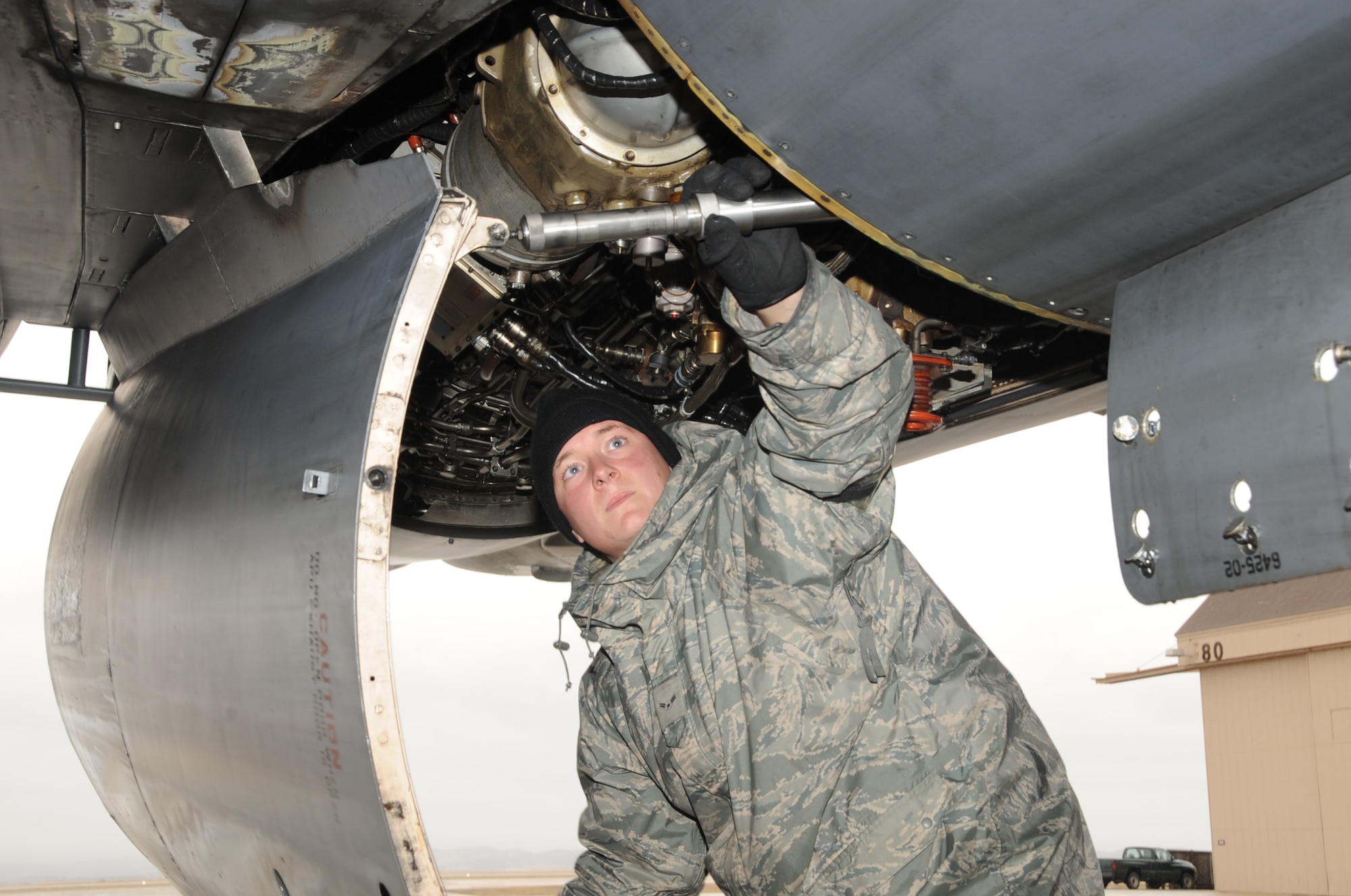 ELLSWORTH AFB, S.D. -- Airmen 1st Class Matthew Bartley, 28th Aircraft Maintenance Squadron crew chief, closes an engine compartment door on the B-1B Lance, Oct. 28.  Ellsworth Airmen endure freezing temperatures and severe wind while working on the B-1. (U.S. Air Force photo/Airman 1st Class Anthony Sanchelli)