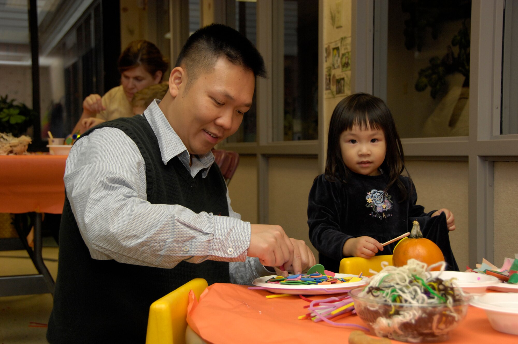 HANSCOM AIR FORCE BASE, Mass. - Joanne Mui decorates a pumpkin with her father, Hueming Mui, during the Child Development Center’s Parent Child Pumpkin Decorating Activity on Oct. 27. Children enrolled at the Center decorated pumpkins with their family members while enjoying donuts and apple cider. Hanscom is celebrating Air Force Family Week next week with a number of events and activities across the base for families to participate in. For more information go to http://www.hanscom.af.mil/hanscomyearoftheairforcefamily/index.asp.(U.S. Air Force photo by Mark Herlihy)