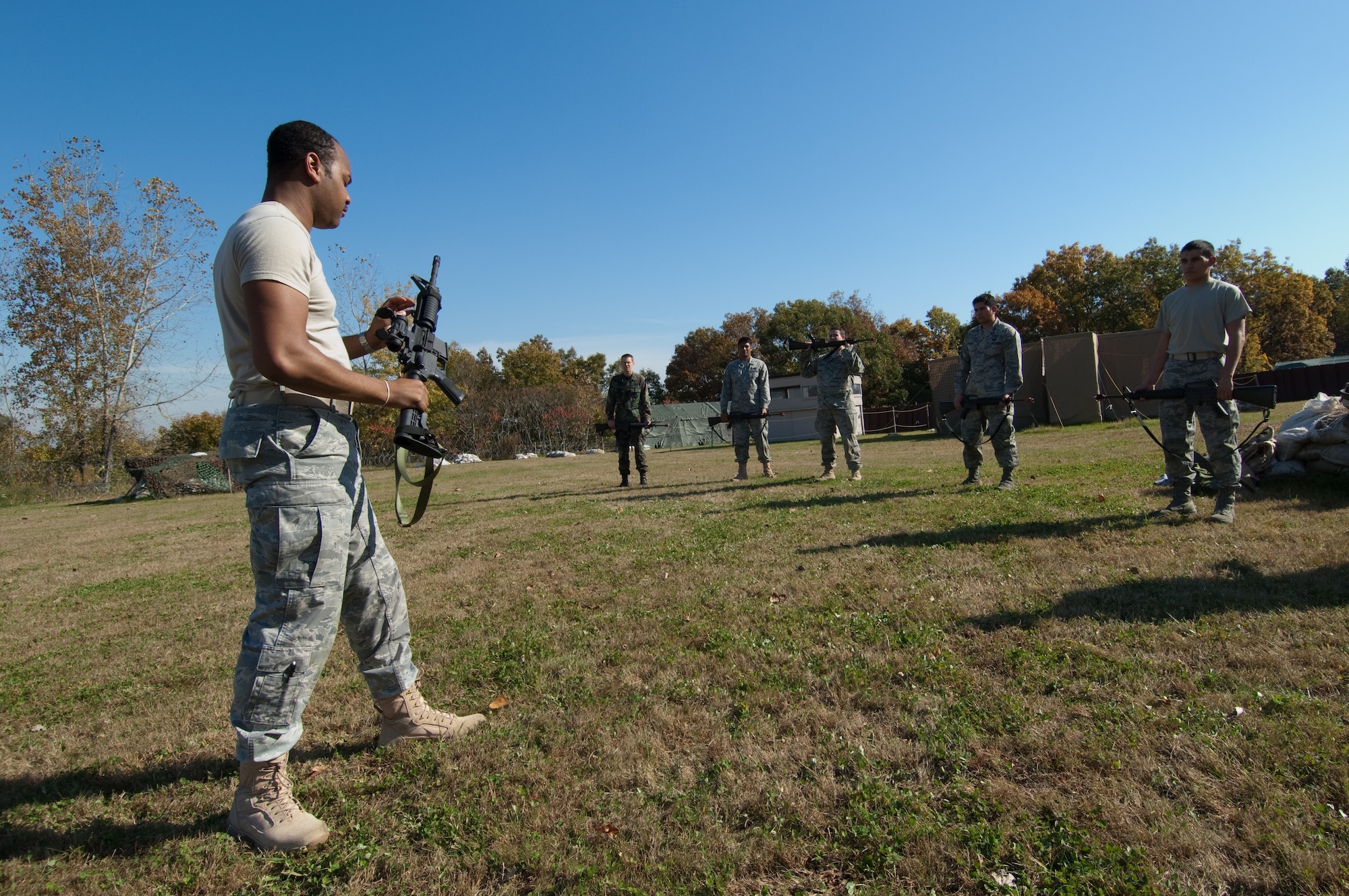 HANSCOM AIR FORCE BASE, Mass. - Staff Sgt. Brandon Jenkins, 66th Security Forces Squadron trainer, trains a group of nine Hanscom Airmen during the Expeditionary Airmen Combat Skills Training session on Oct. 22 at Camp Patriot. The nine Airmen, all scheduled to deploy in the near future, learned such tactics as rifle fighting, moving under fire, survival, and M-16 operations, in the 19-hour two-day course. (U.S. Air Force Photo by Rick Berry)