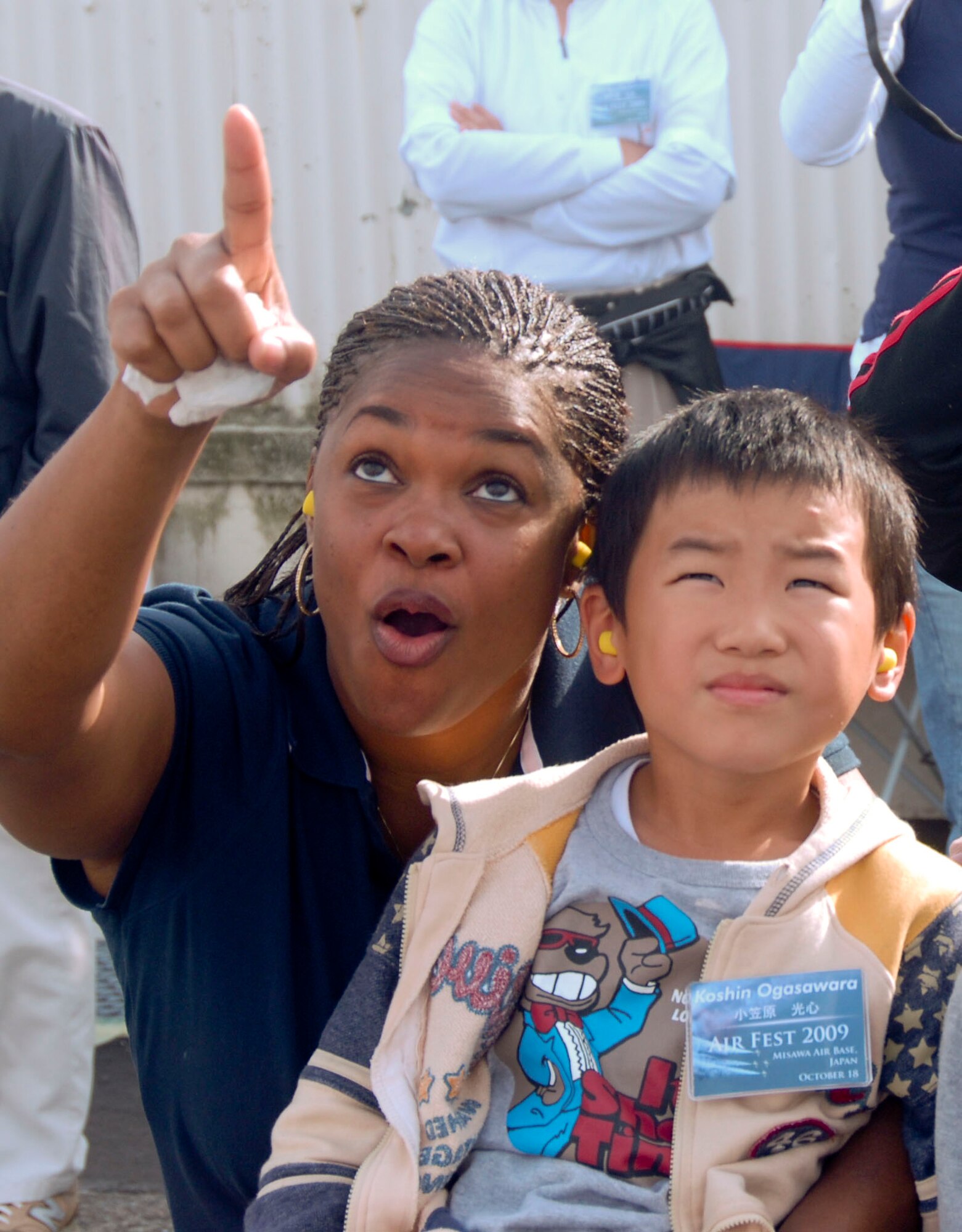 MISAWA AIR BASE, Japan -- Senior Master Sgt. Margo Miller, a representative of Misawa Top Three organization, watches the U.S. Air Force Thunderbirds perform with Koshin Ogasawara during the Misawa Air Fest Oct. 18, 2009. More than 50 Japanese children, to include those with special needs, and their parents were invited to take part in a unique community relations event that included viewing the air show, playing at the Weasel's Den and meeting the U.S. Air Force Thunderbirds. (U.S. Air Force photo/Staff Sgt. Rachel Martinez)
