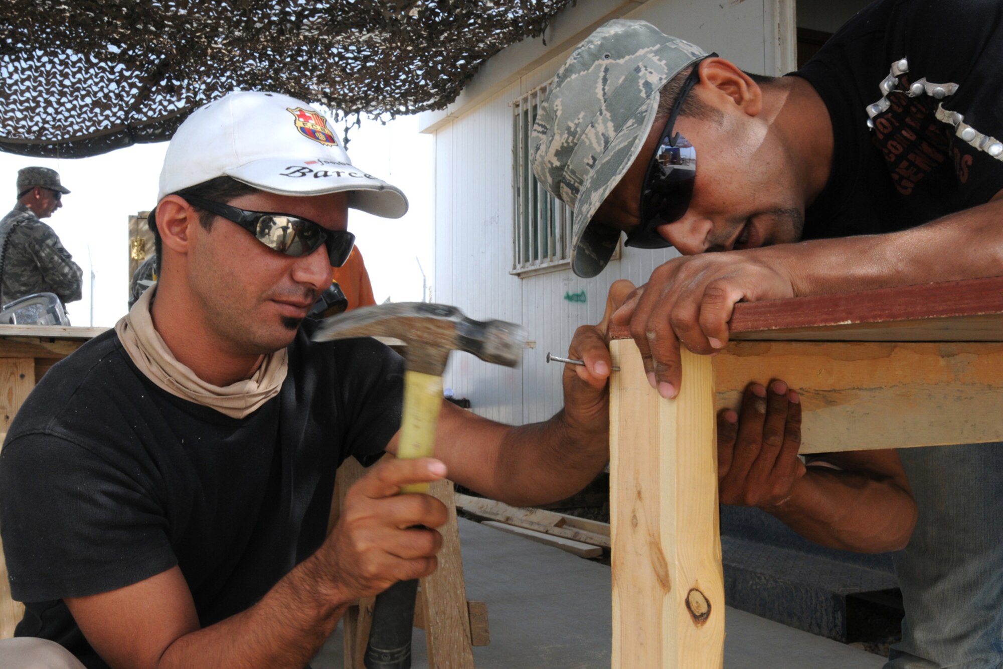 KIRKUK REGIONAL AIR BASE, Iraq - Qusay Ahmad and Ahmad Hussein, local Iraqi workers, nail pieces of wood together to create a desk that will be used in a classroom for the Iraqi Police counter explosive team here Oct. 17.  The 506th Expeditionary Civil Engineer Squadron works with local nationals who are employed by a local contractor on base to develop their skills which allow them to work and complete job orders.  (U.S. Air Force photo/Staff Sgt. Daniel Martinez)