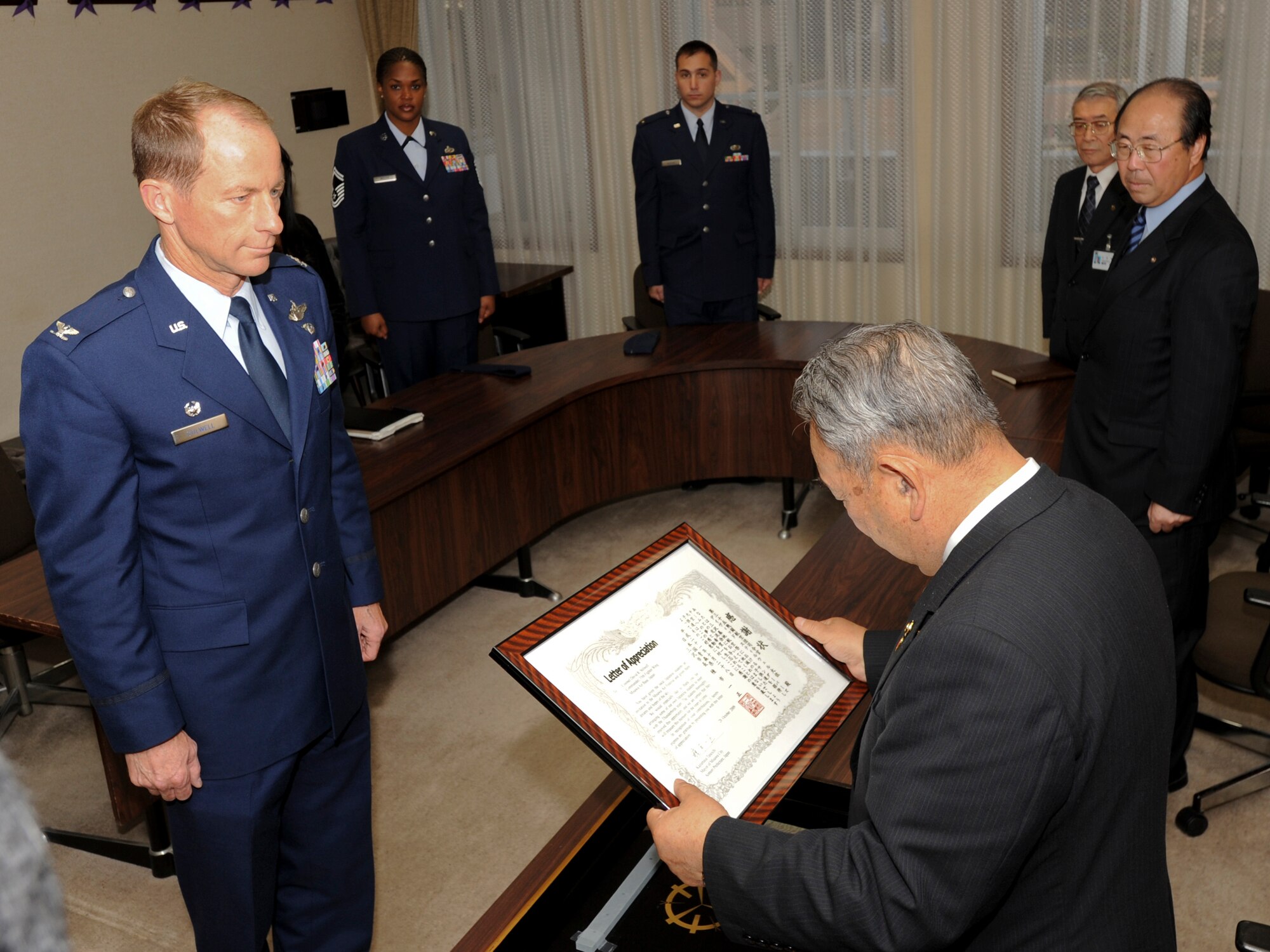 MISAWA CITY, Japan -- Col. David Stilwell, 35th Fighter Wing commander, receives a letter of appreciation from Misawa City Mayor Kazumasa Taneichi Oct. 28 at the Misawa City Office. Mayor Taneichi thanked the 35th FW for its participation in a community relations event that brought 50 special needs children on base and allowed them to meet and interact with the U.S. Air Force Thunderbirds demonstration team during Air Fest 2009 Oct. 18. (U.S. Air Force photo/Senior Airman Jamal D. Sutter)
