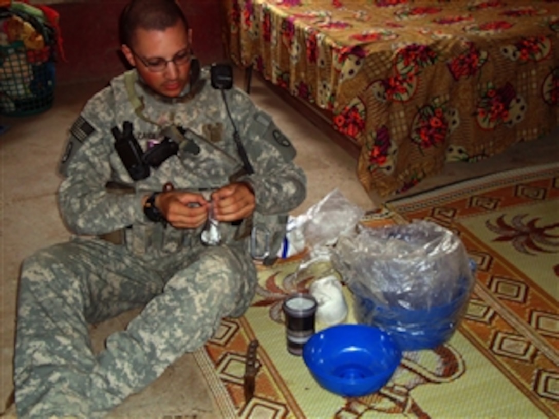 U.S. Army 2nd Lt. Zaidi, assigned to Charlie Troop, 1st Platoon, 150th Cavalry Regiment, builds a drinking water filtration system for an Iraqi family inside their home near Radwaniyah, Iraq, on Oct. 24, 2009.  Many homes were given the water filters to help improve their drinking water.  